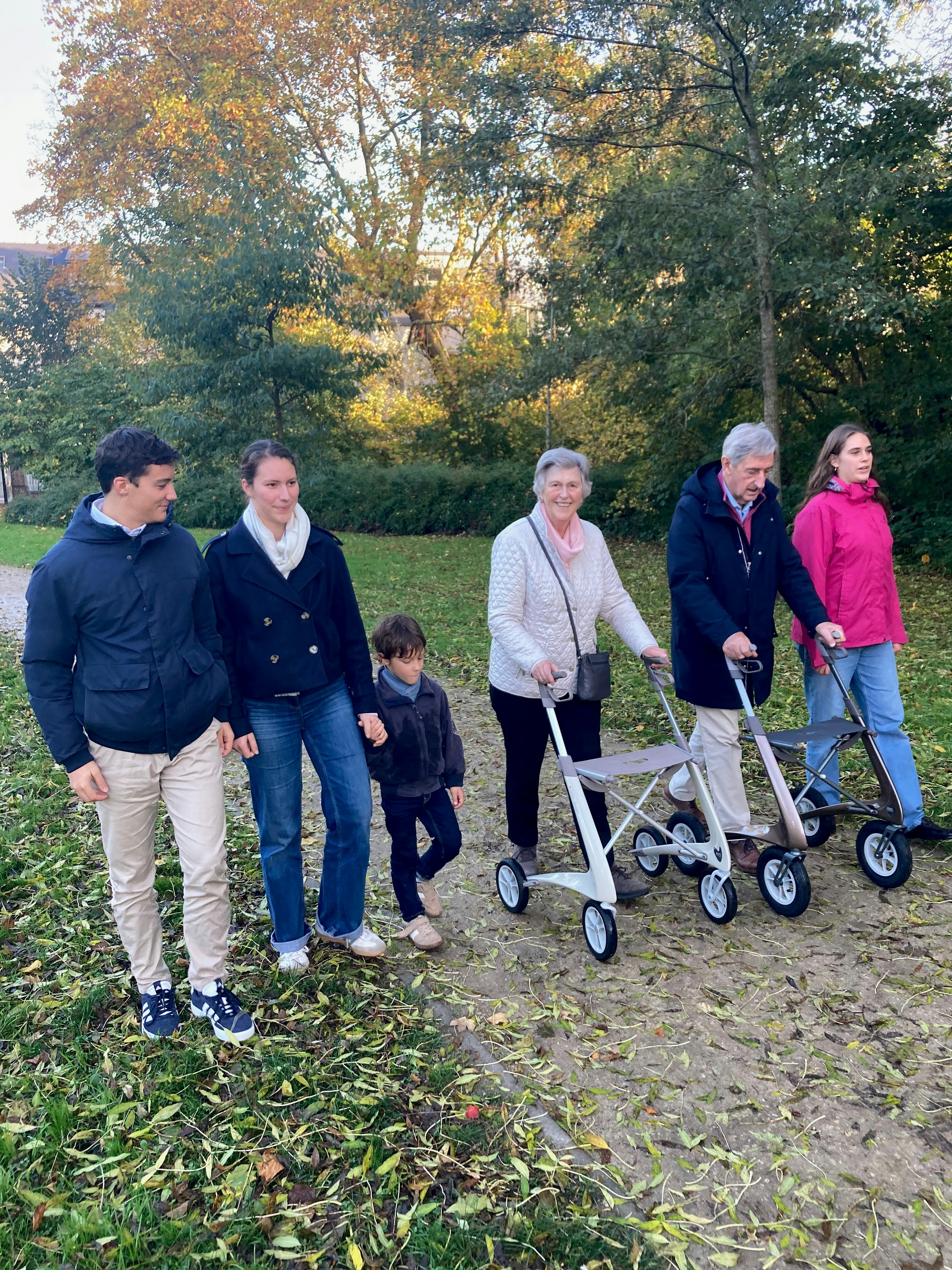 Family walks together on a path in autumn park