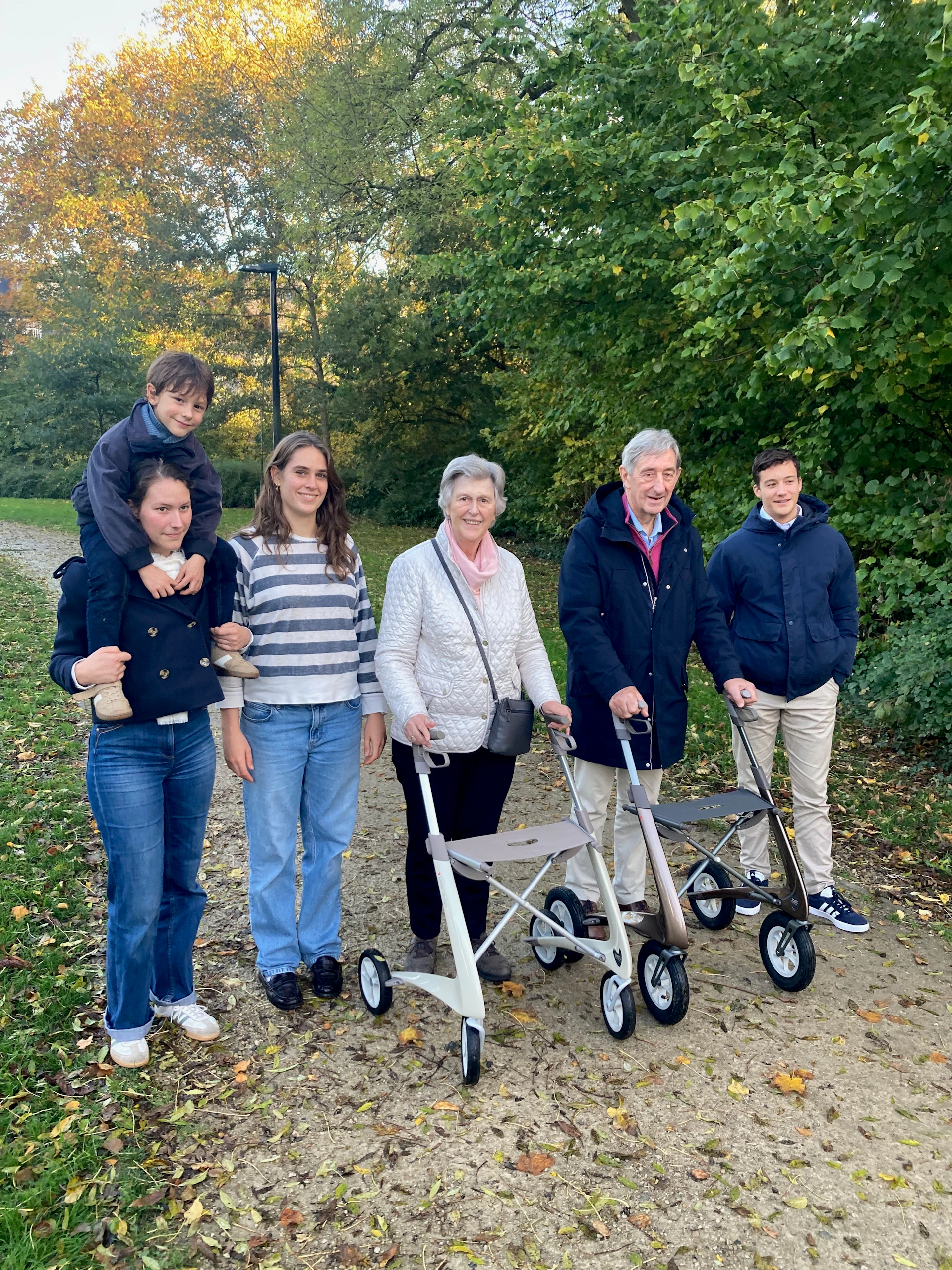 A multi-generational family walking in a park.