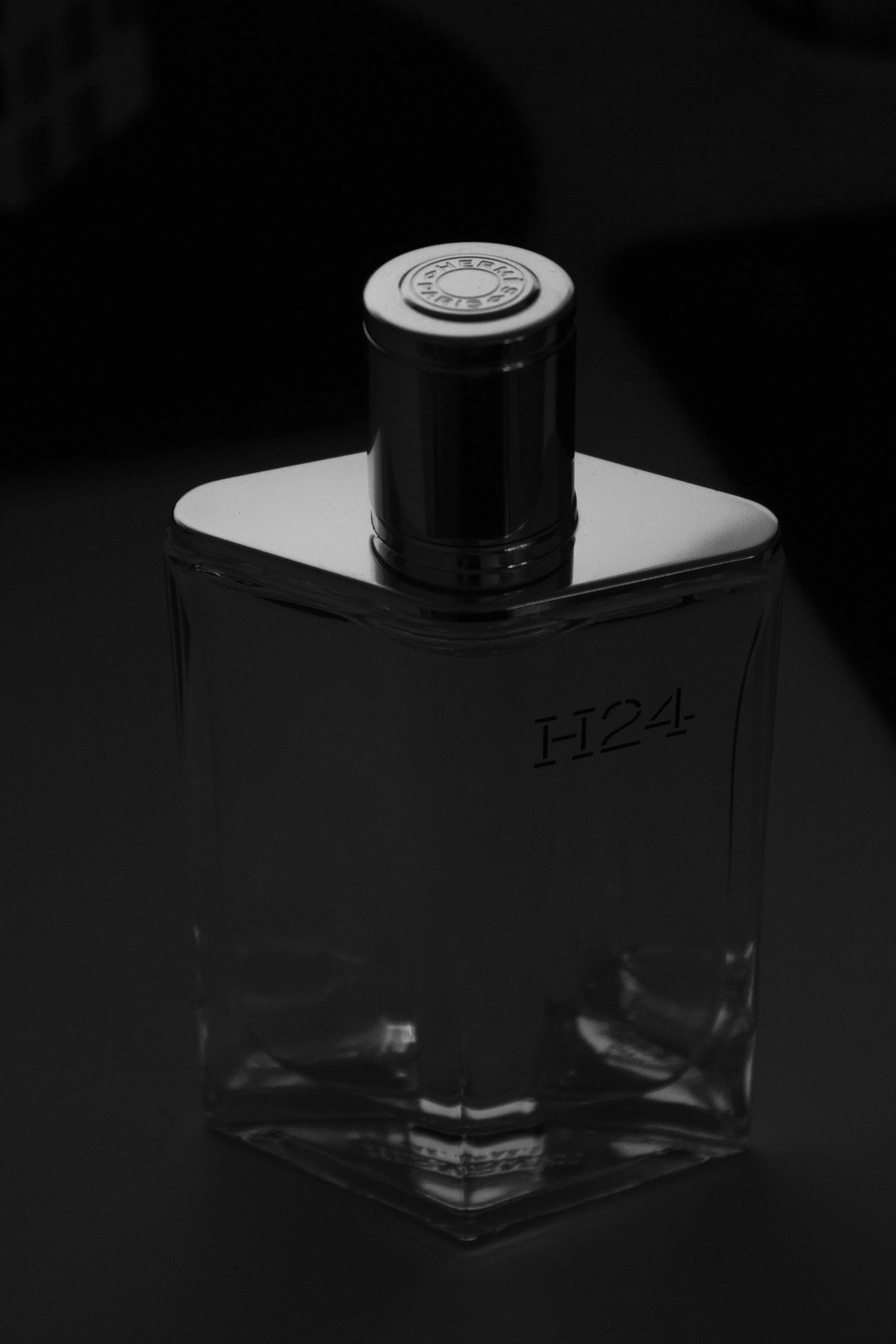 A clear glass perfume bottle with silver cap