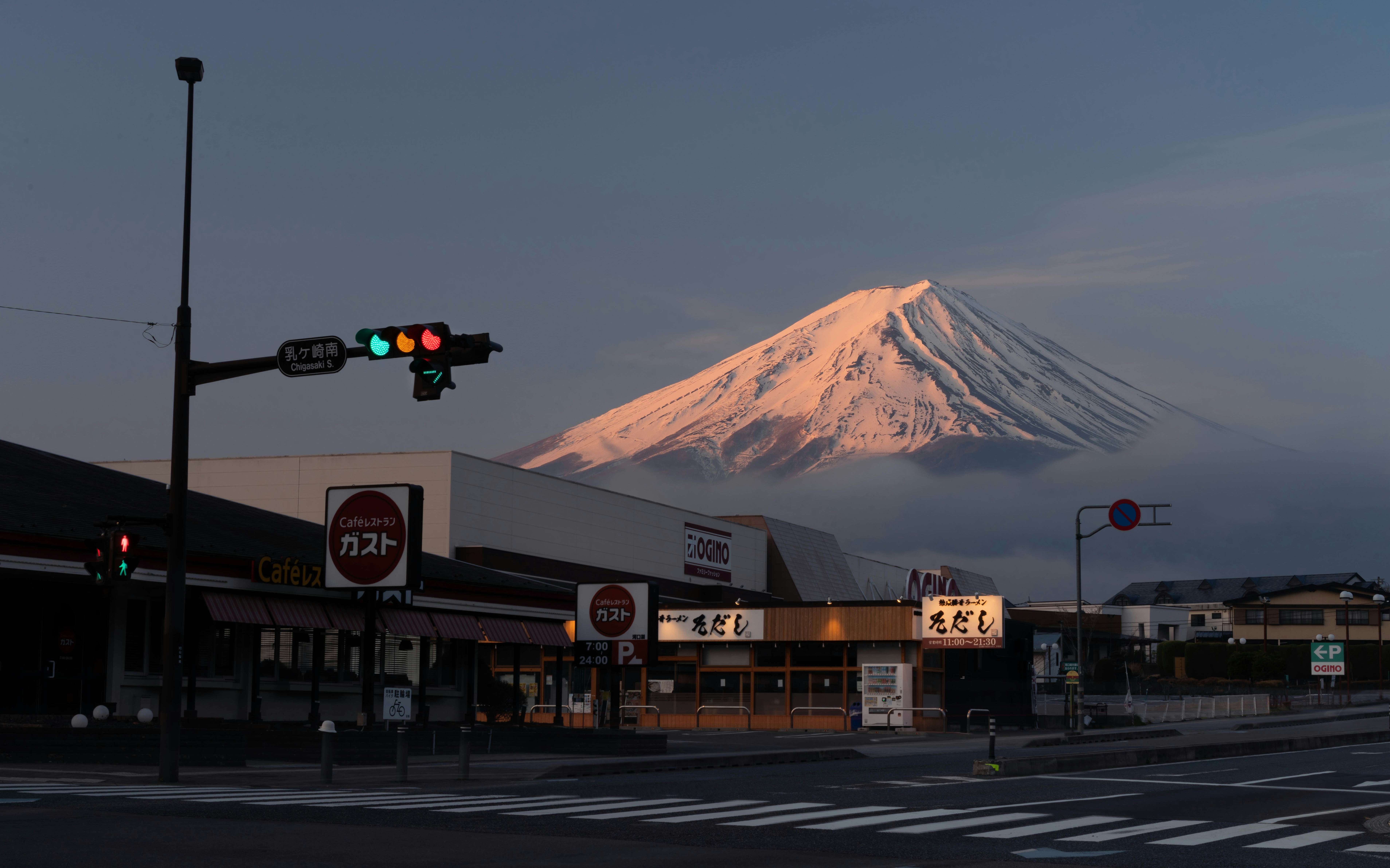 Mount fuji illuminated by sunrise over misty landscape.