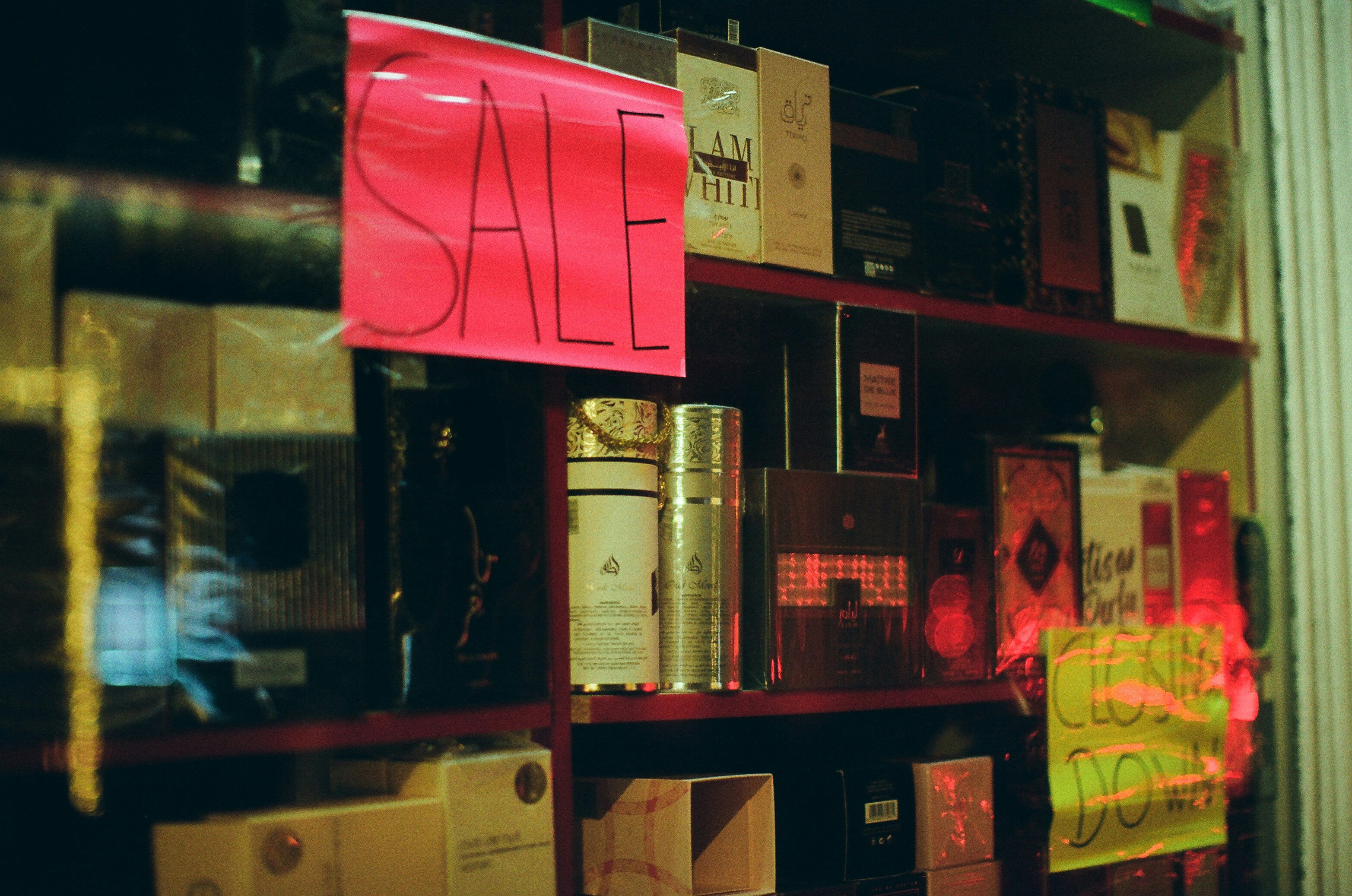 Shelves of perfume bottles with sale signs.
