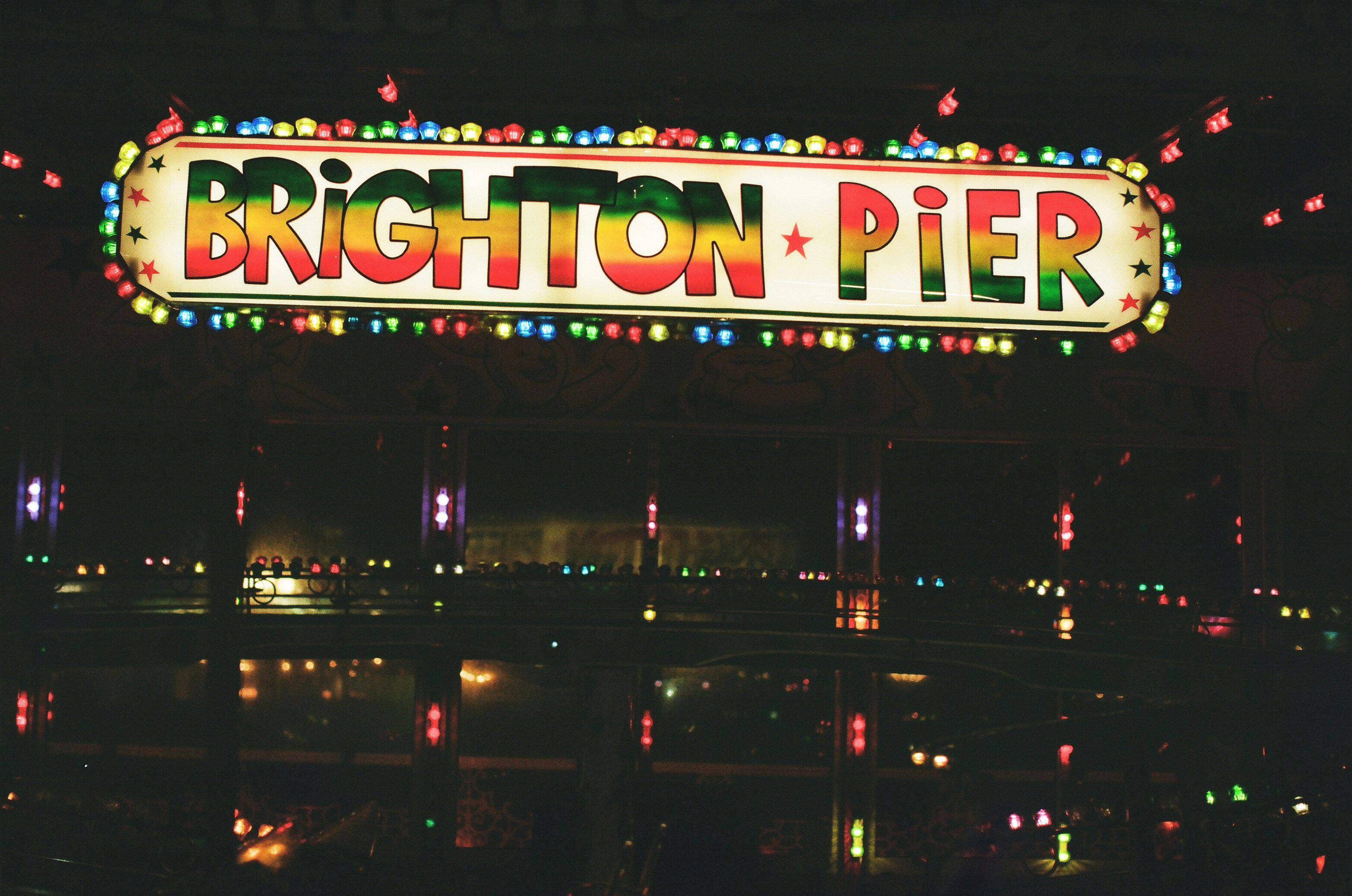 Brighton pier illuminated with colorful lights at night