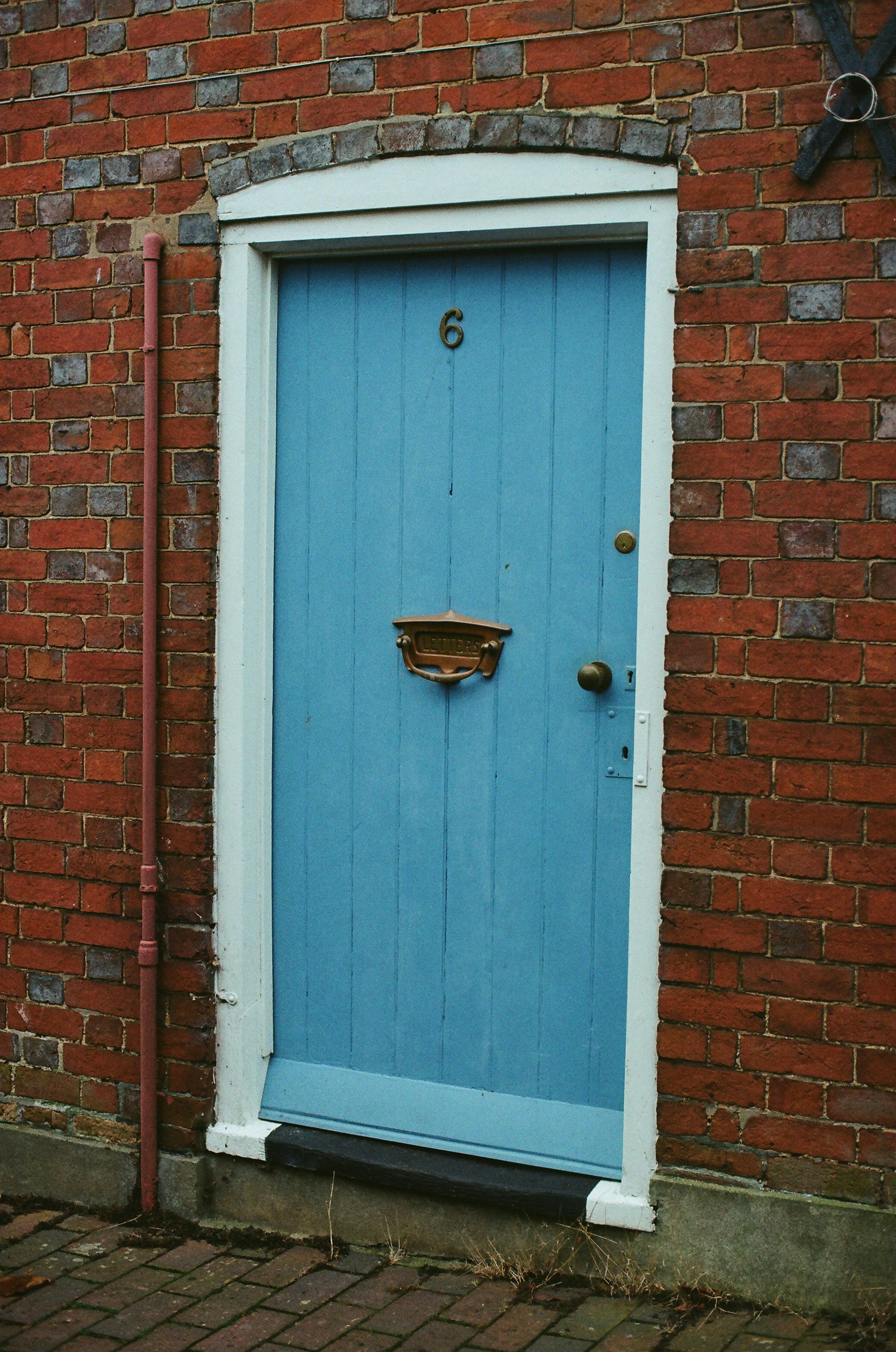 A blue wooden door with number six.