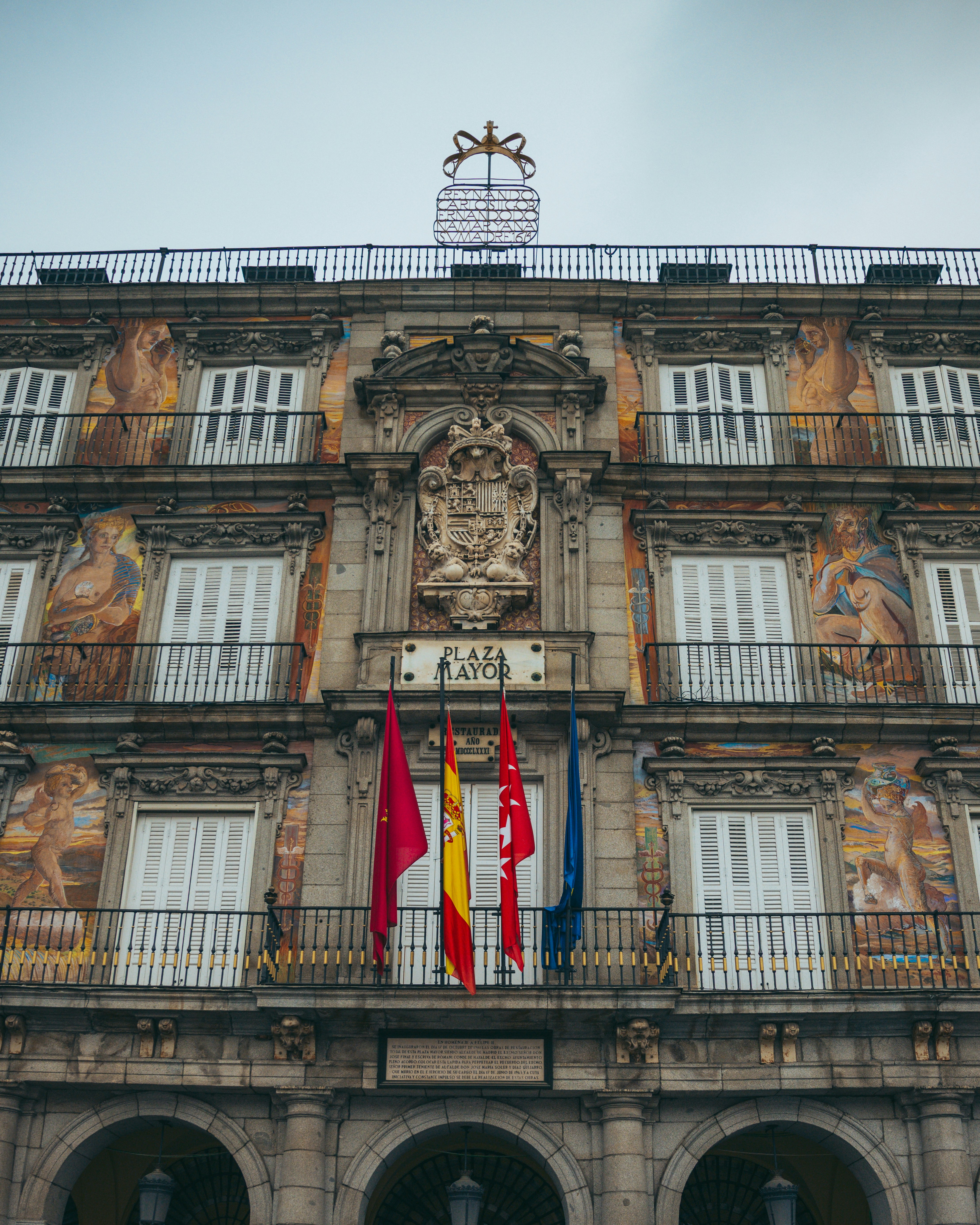 Plaza mayor building with flags under cloudy sky