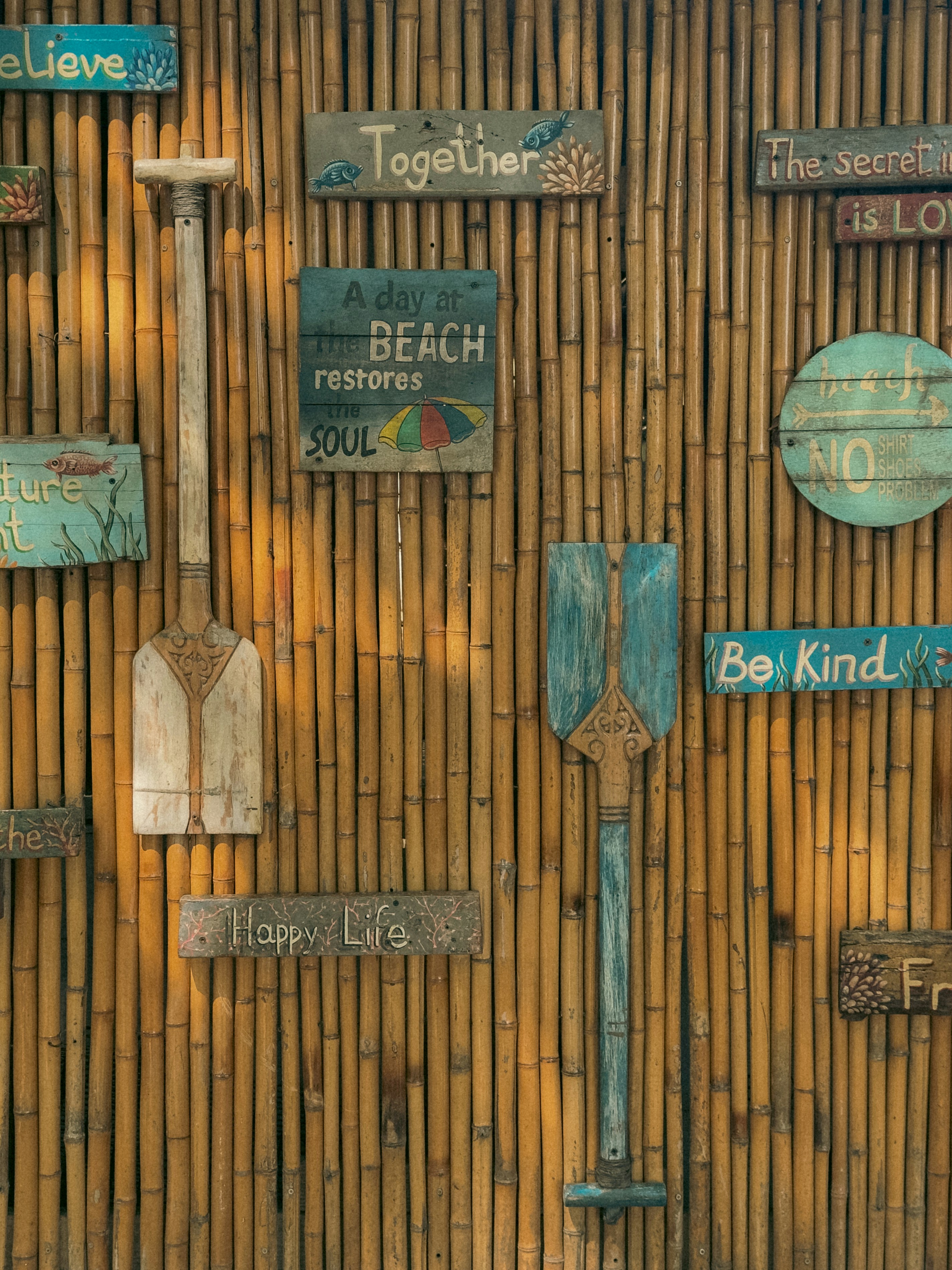 Decorative paddles and signs on bamboo wall