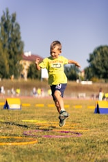 Young boy jumps through hoops during outdoor activity.