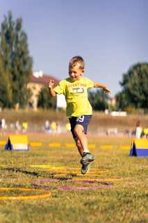 Young boy jumps through hoops during outdoor activity.