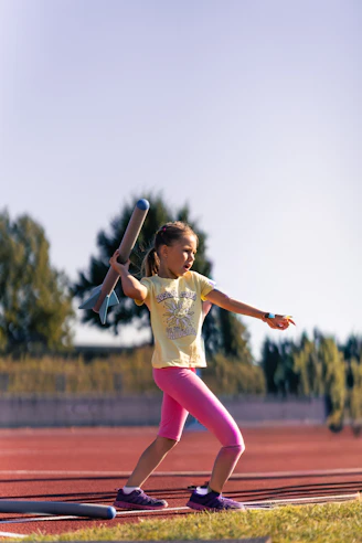 Young girl practicing javelin throw on a track.