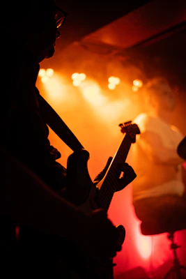 Guitarist performing on stage with orange lights