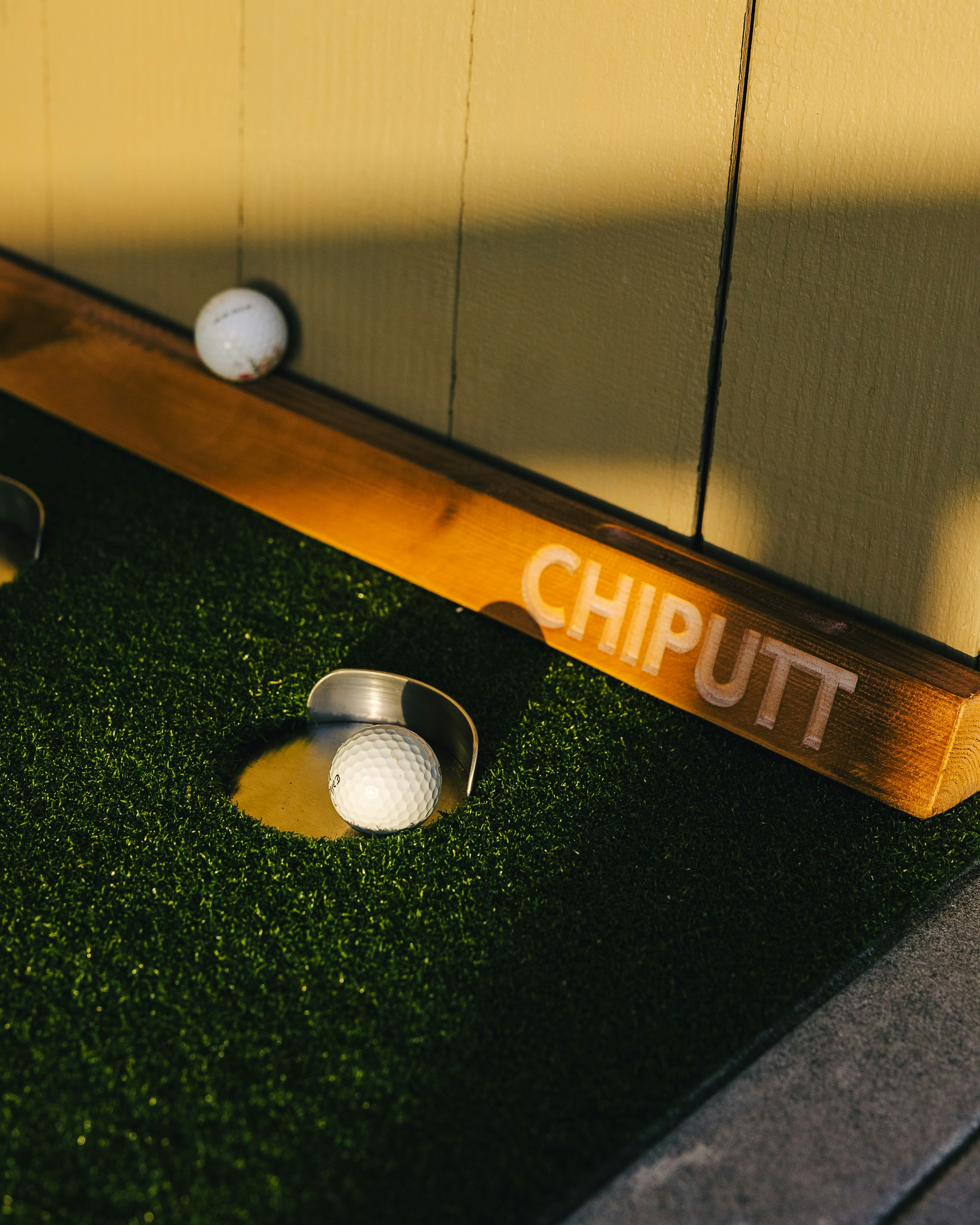 Golf balls on a putting green with chiputt sign.