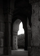 Arched stone passageway leading to trees