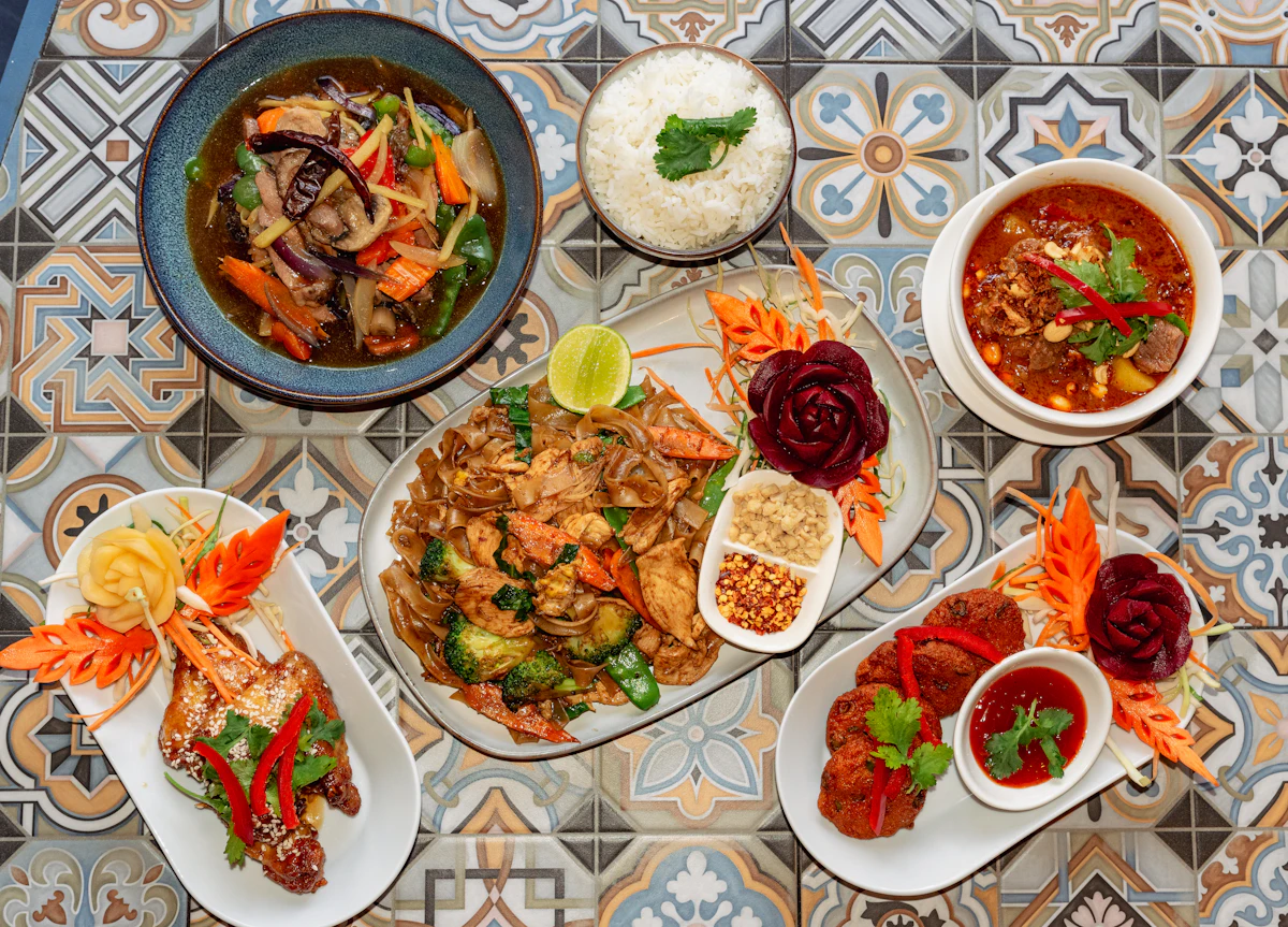 A spread of Thai dishes laid out on a patterned surface