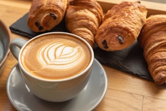Cup of coffee with latte art and croissants