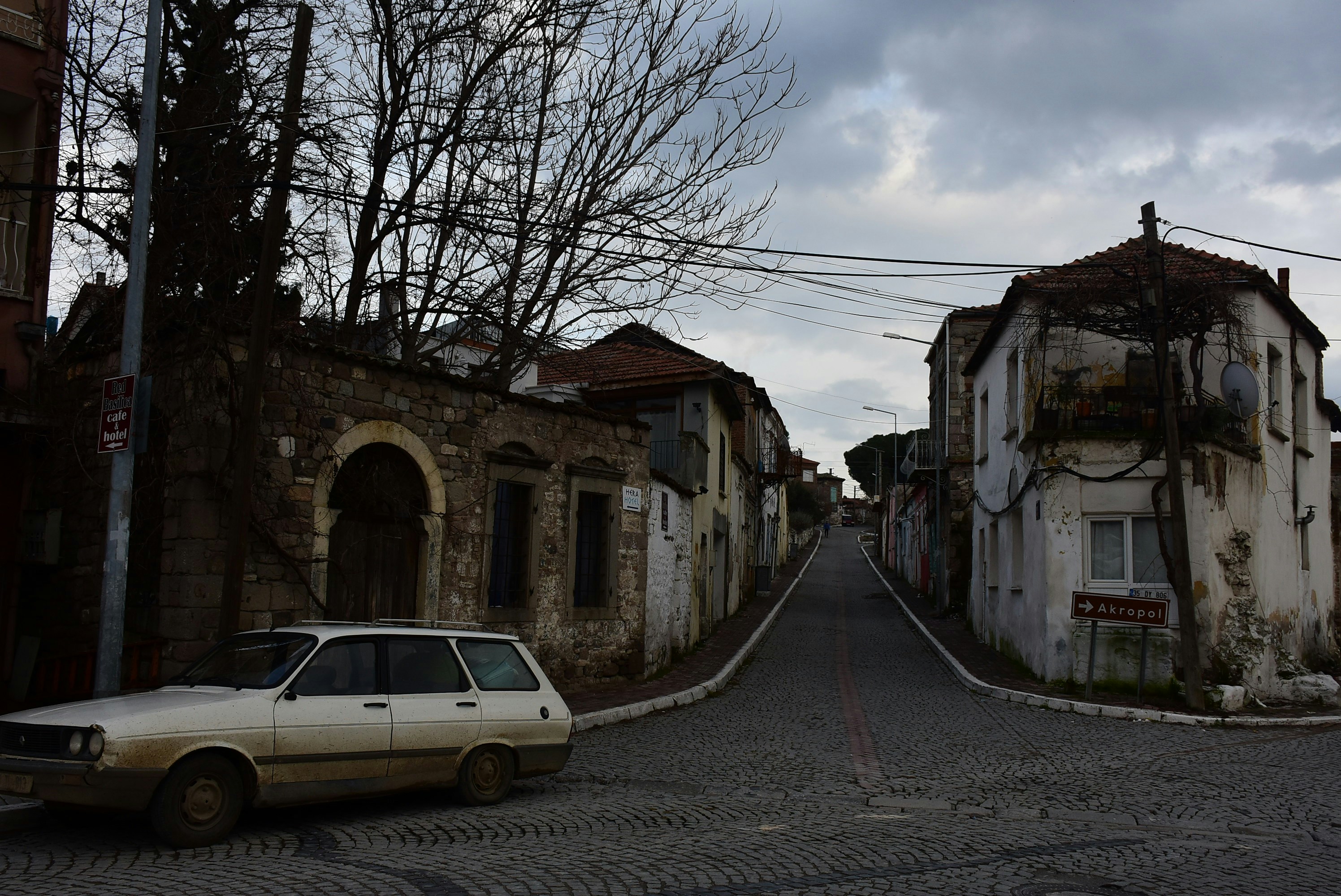 A vintage station wagon parked on a cobblestone street.