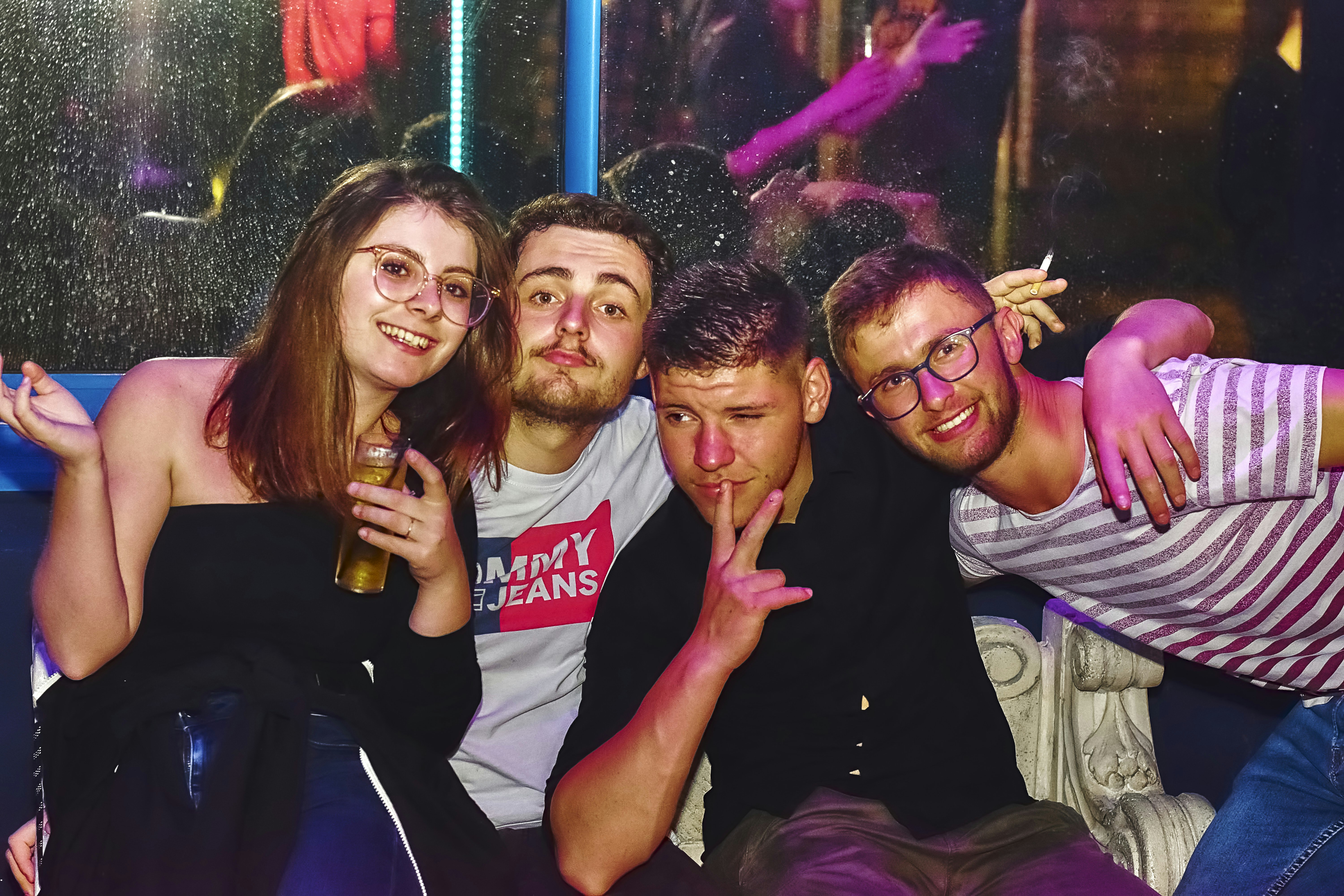 Four friends posing for a selfie in a nightclub