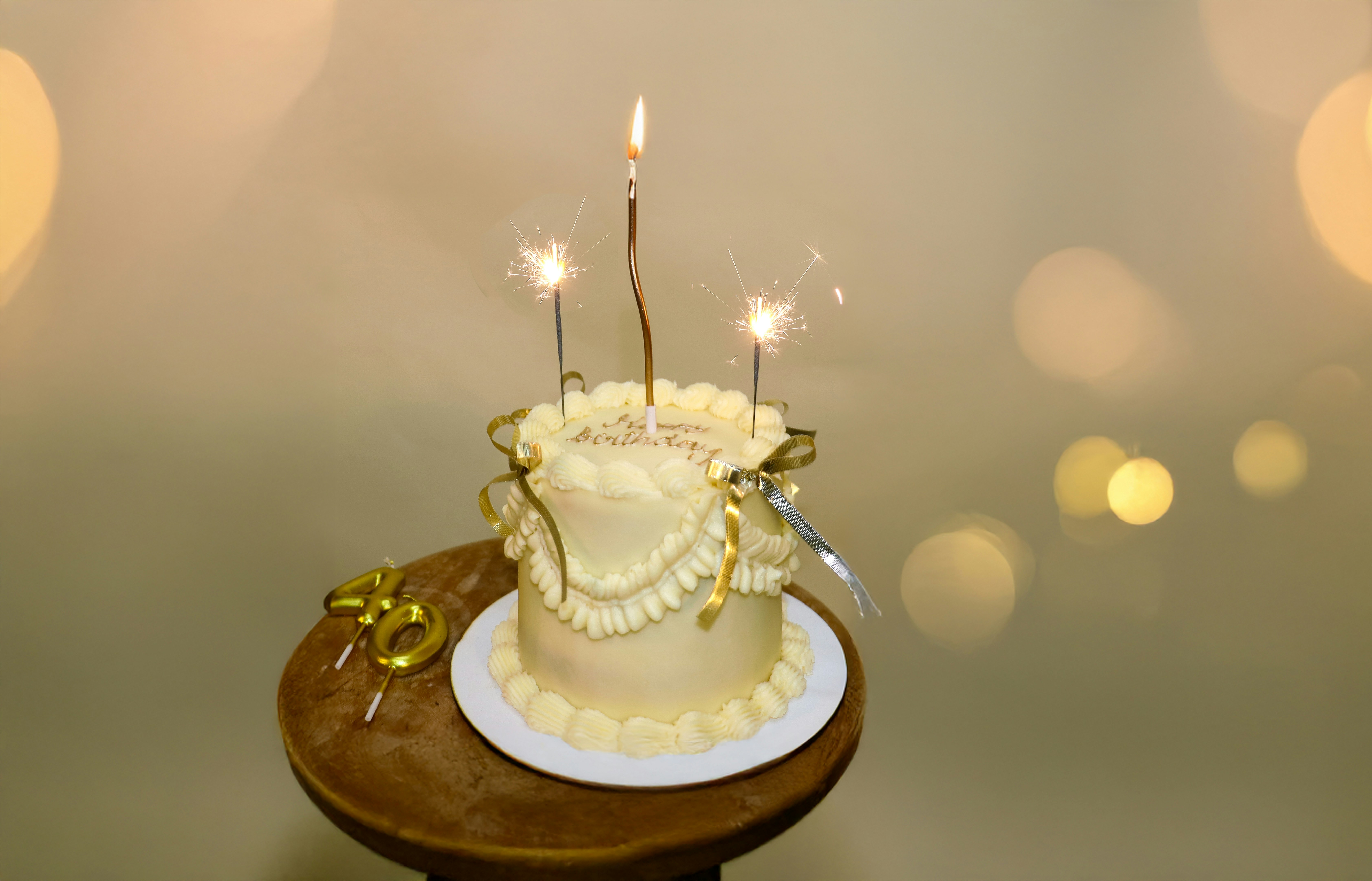 Geburtstagstorte mit Wunderkerzen und goldenen Dekorationen