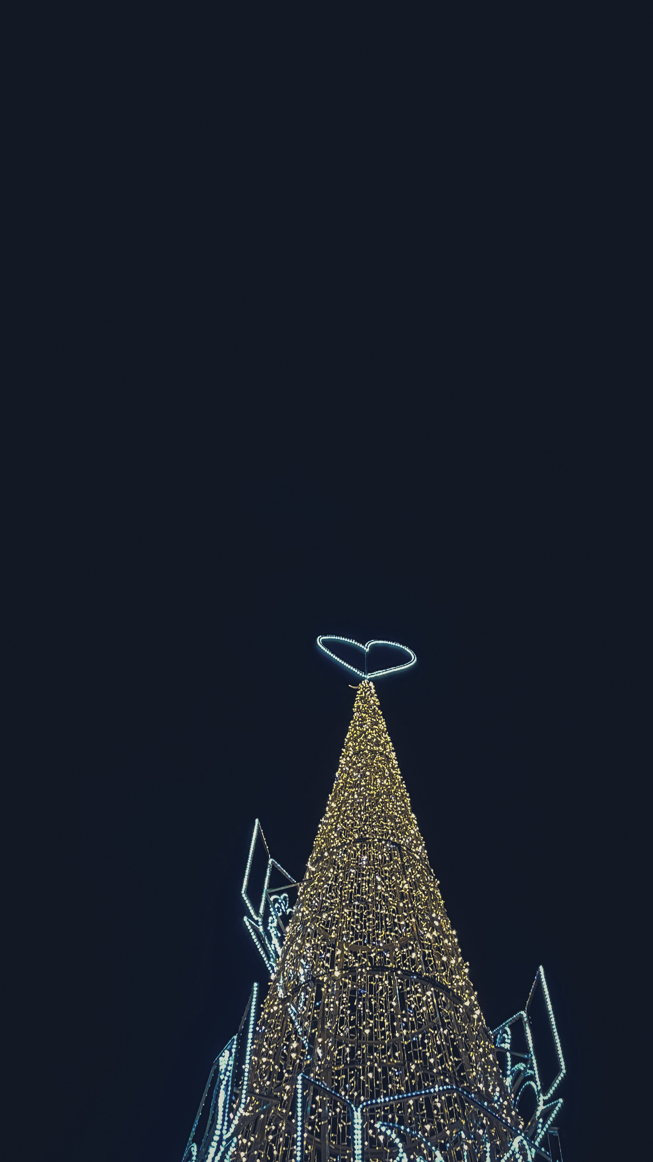 A tall christmas tree adorned with golden lights.
