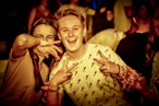 Two young people making peace signs at a party.