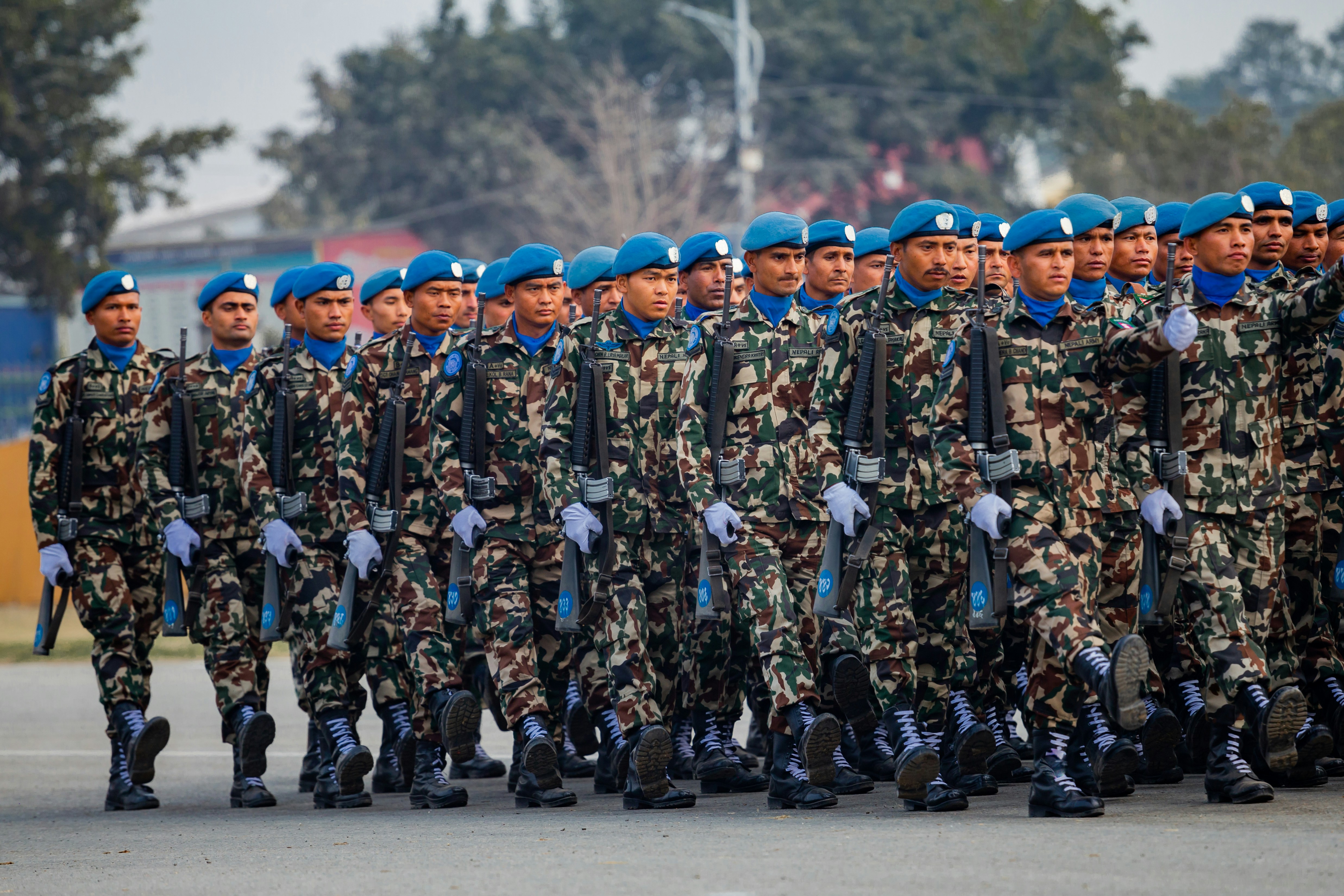 Soldados con uniformes de camuflaje marchando en formación