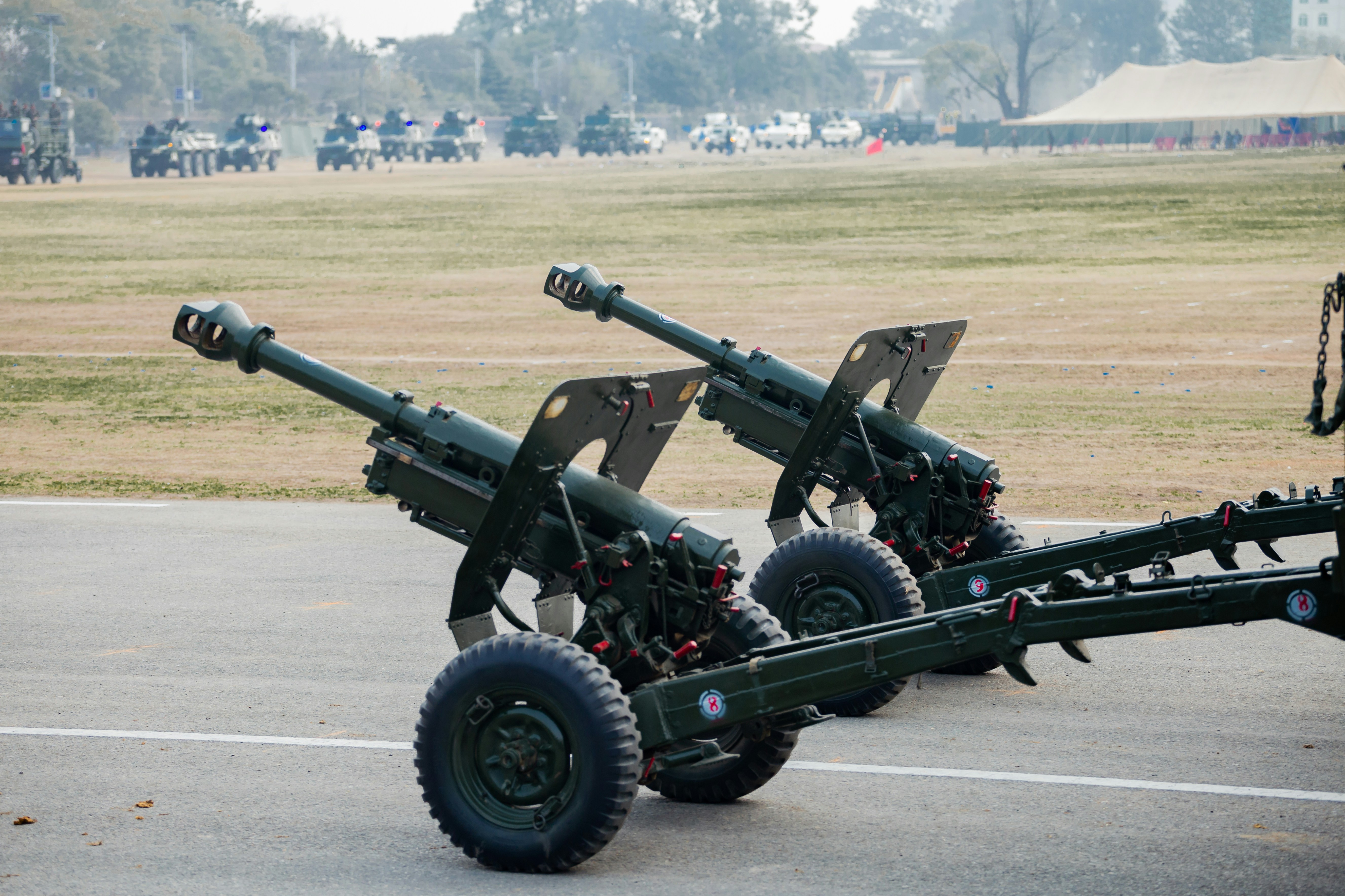 Two artillery cannons on a paved surface