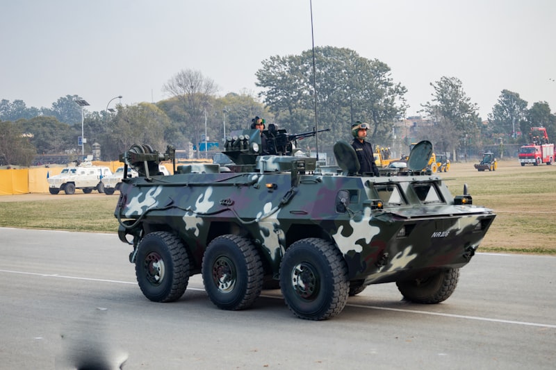 Camouflaged armoured vehicle with soldier on a road