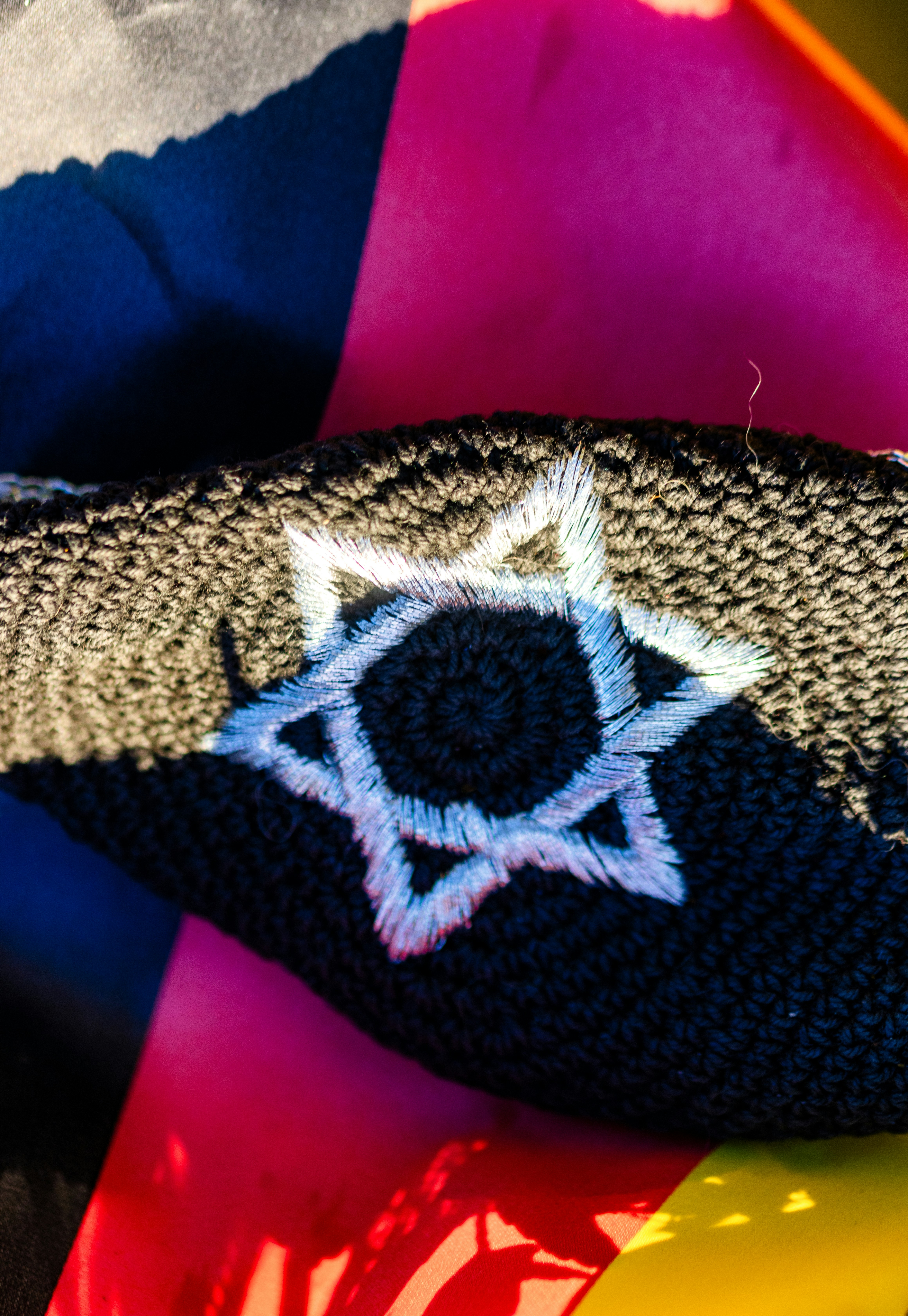 Embroidered star of david on a dark band.