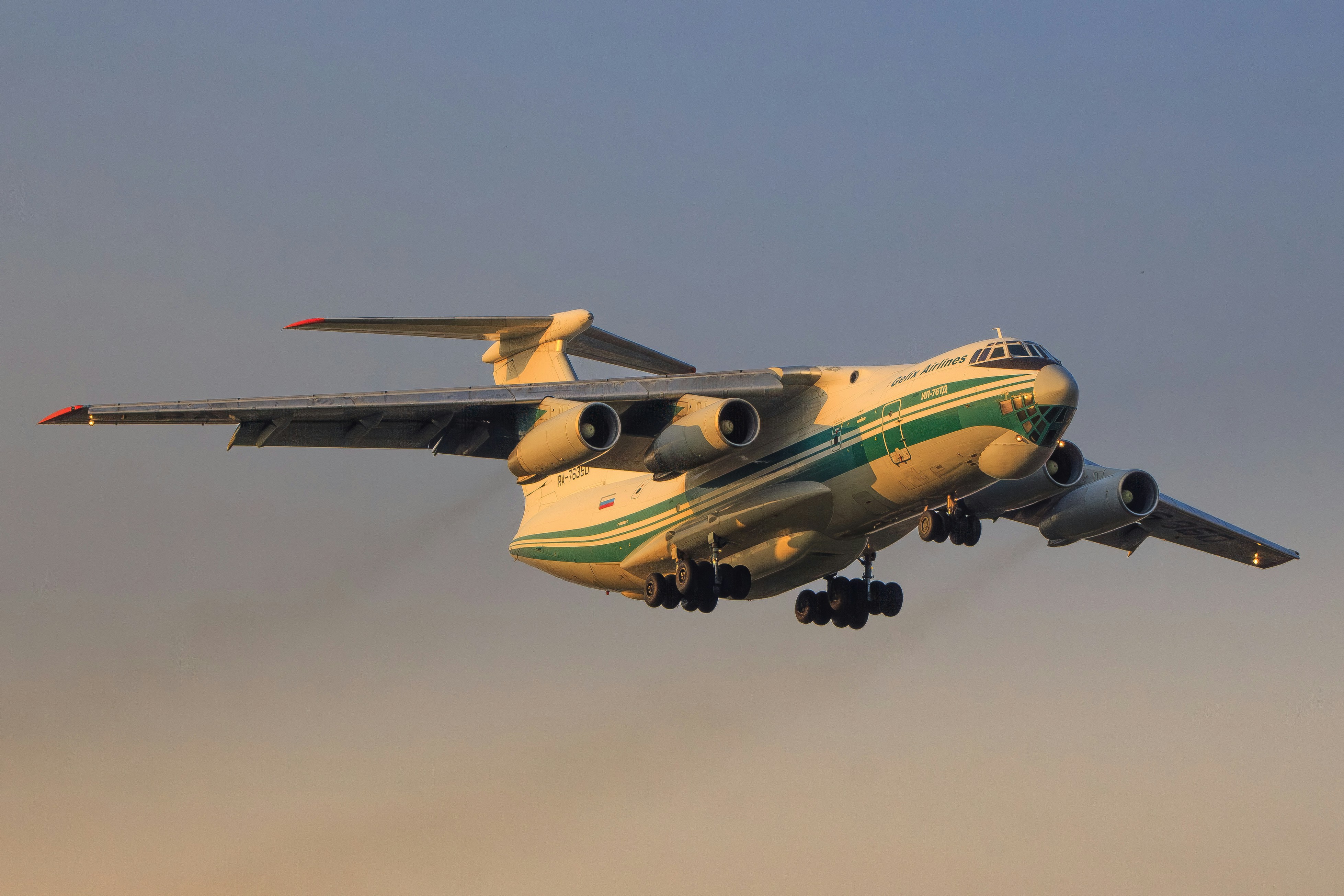 A large cargo airplane taking off into a clear sky.