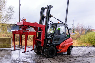 Red forklift with a clamp attachment outdoors