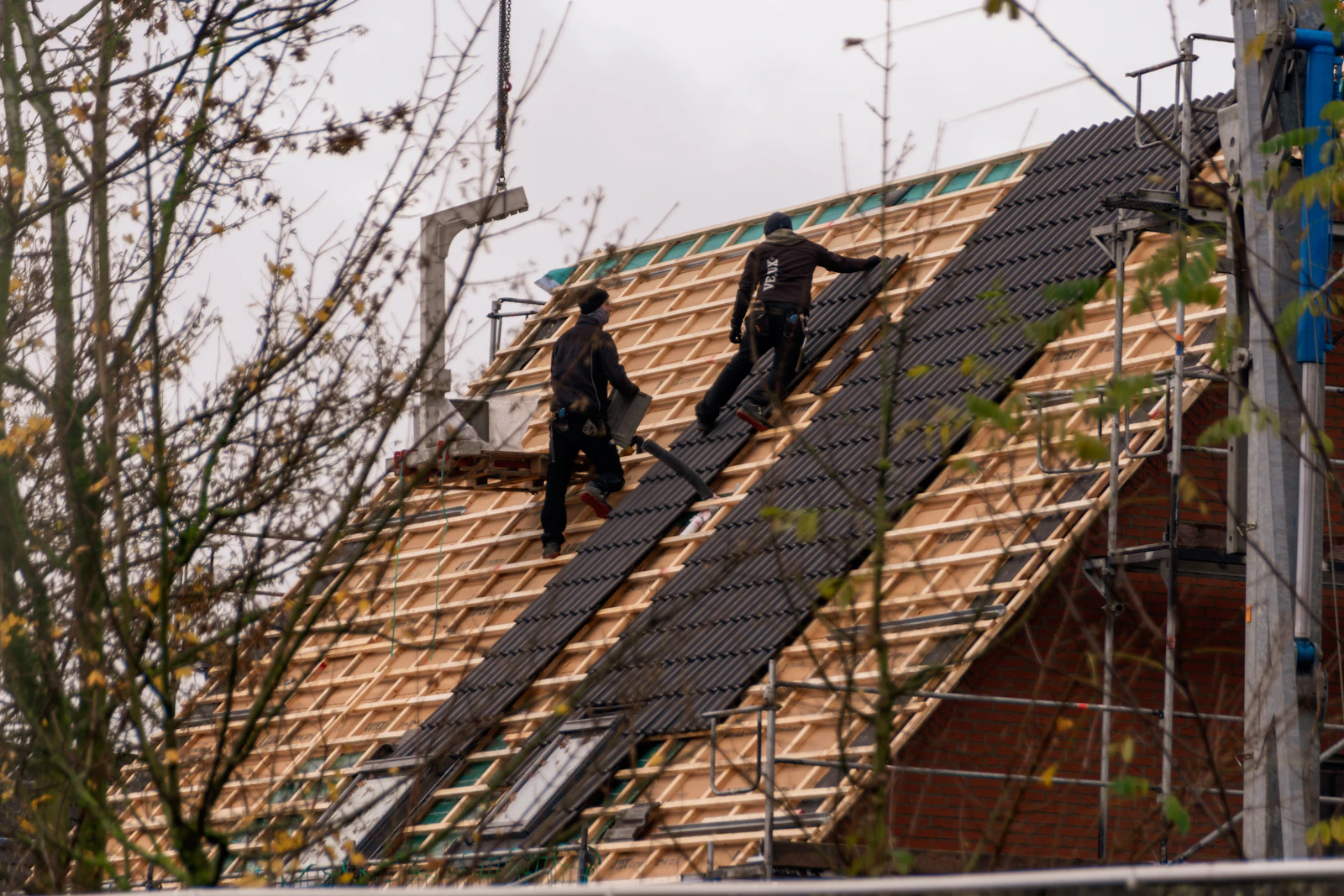 Roofers installing shingles on a residential roof