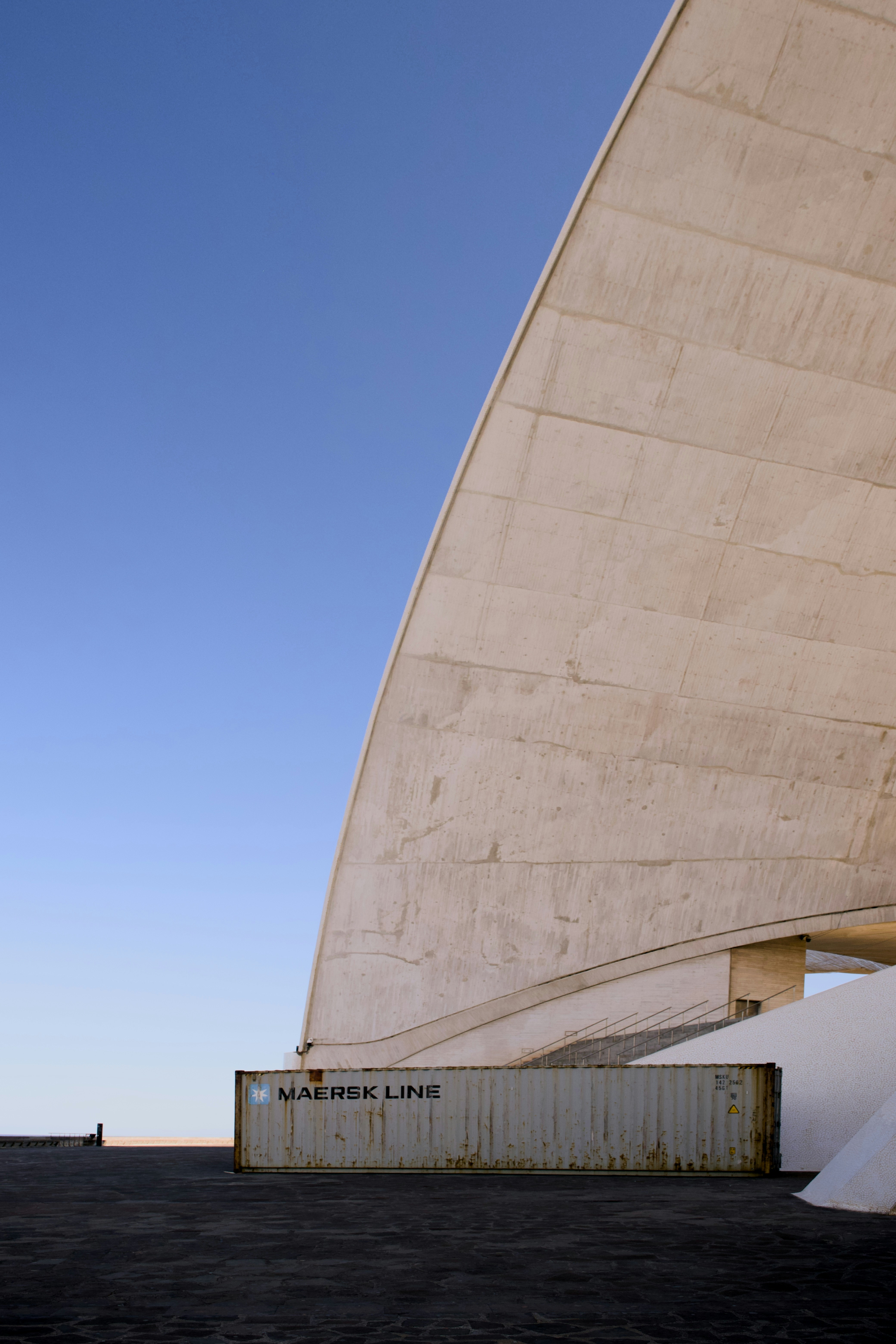 Structure en béton et conteneur maritime sous un ciel bleu
