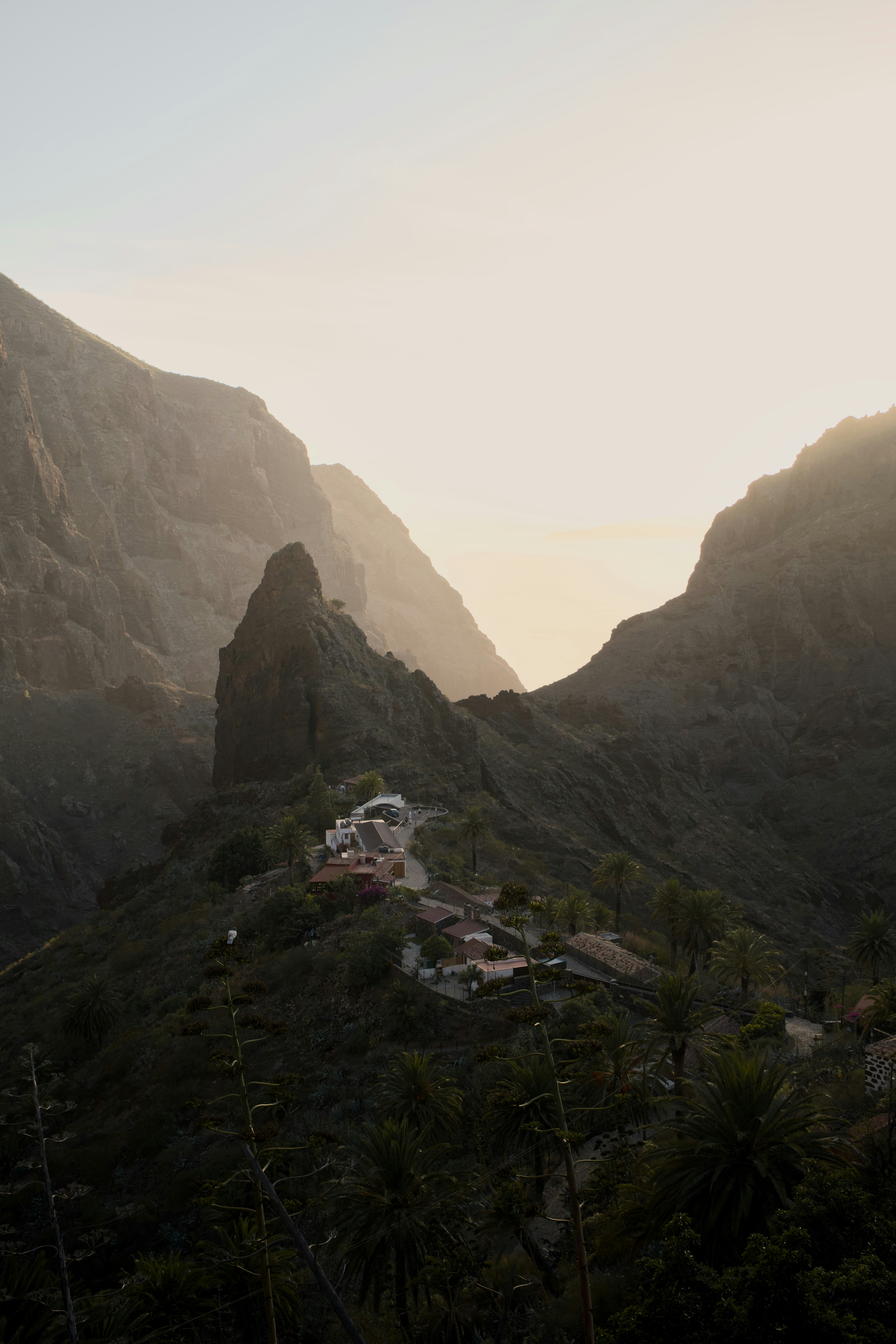 Petit village niché dans un paysage montagneux spectaculaire au coucher du soleil.