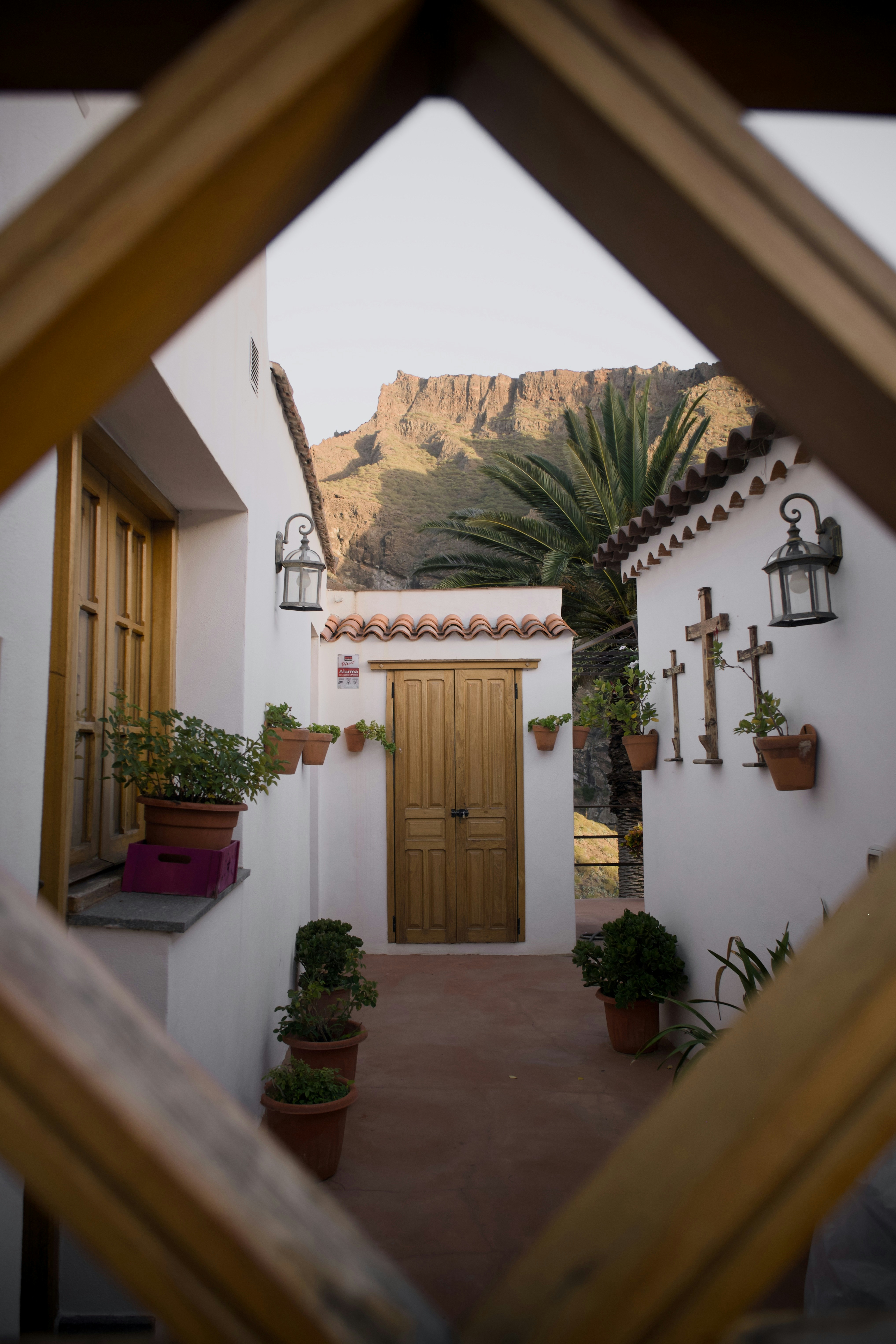 White building with wooden door and potted plants