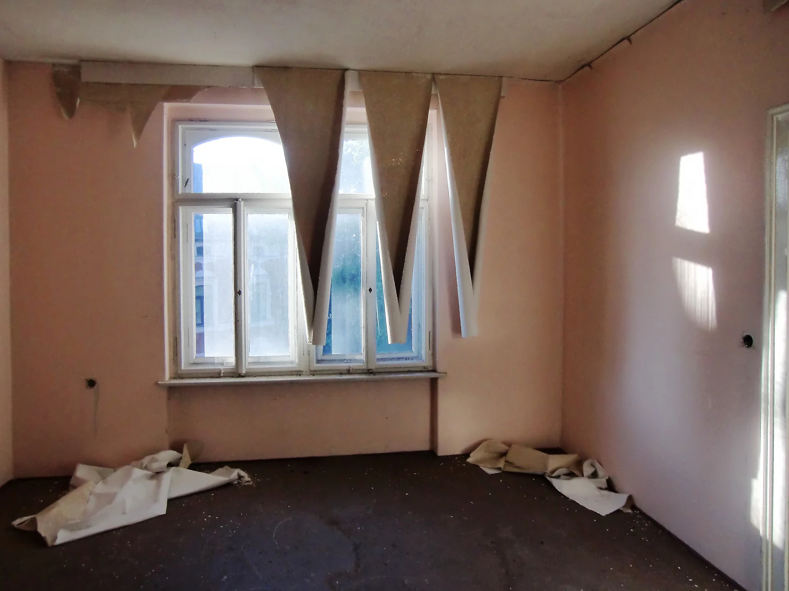 Room mid-remodel with old wallpaper stripped and walls prepped for finish work