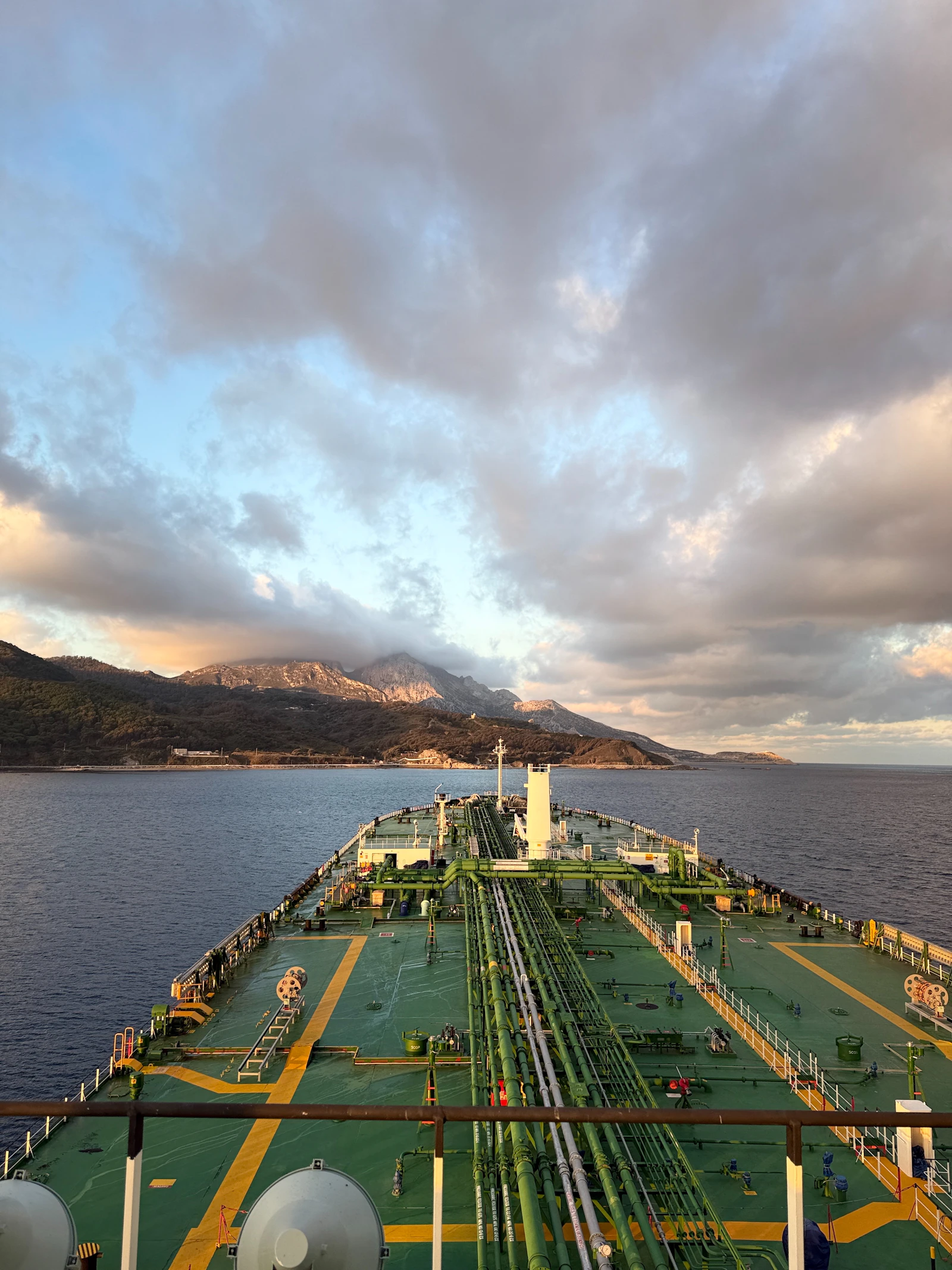Tanker vessel sailing near a mountainous coastline