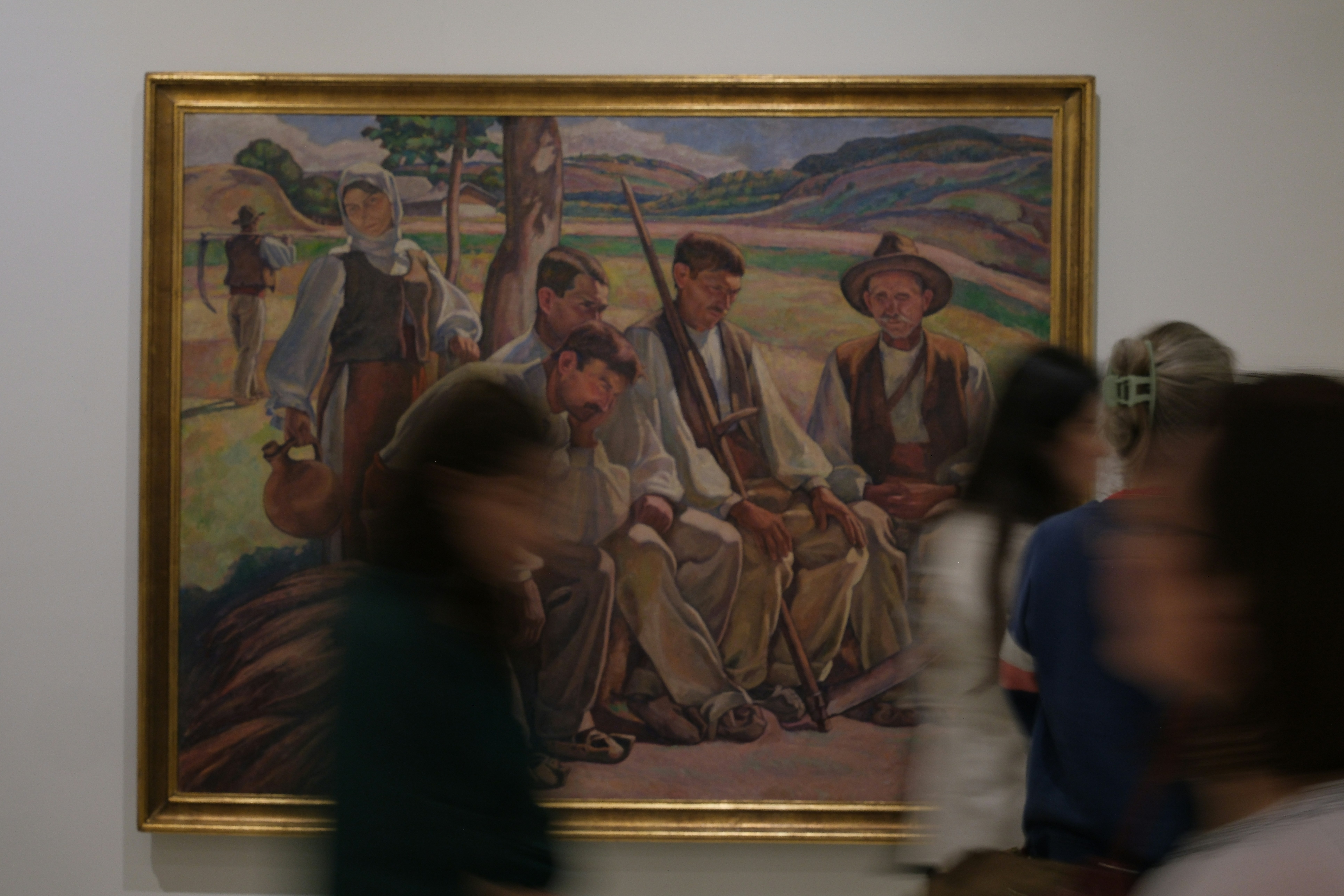 People viewing a painting of men in traditional clothing.