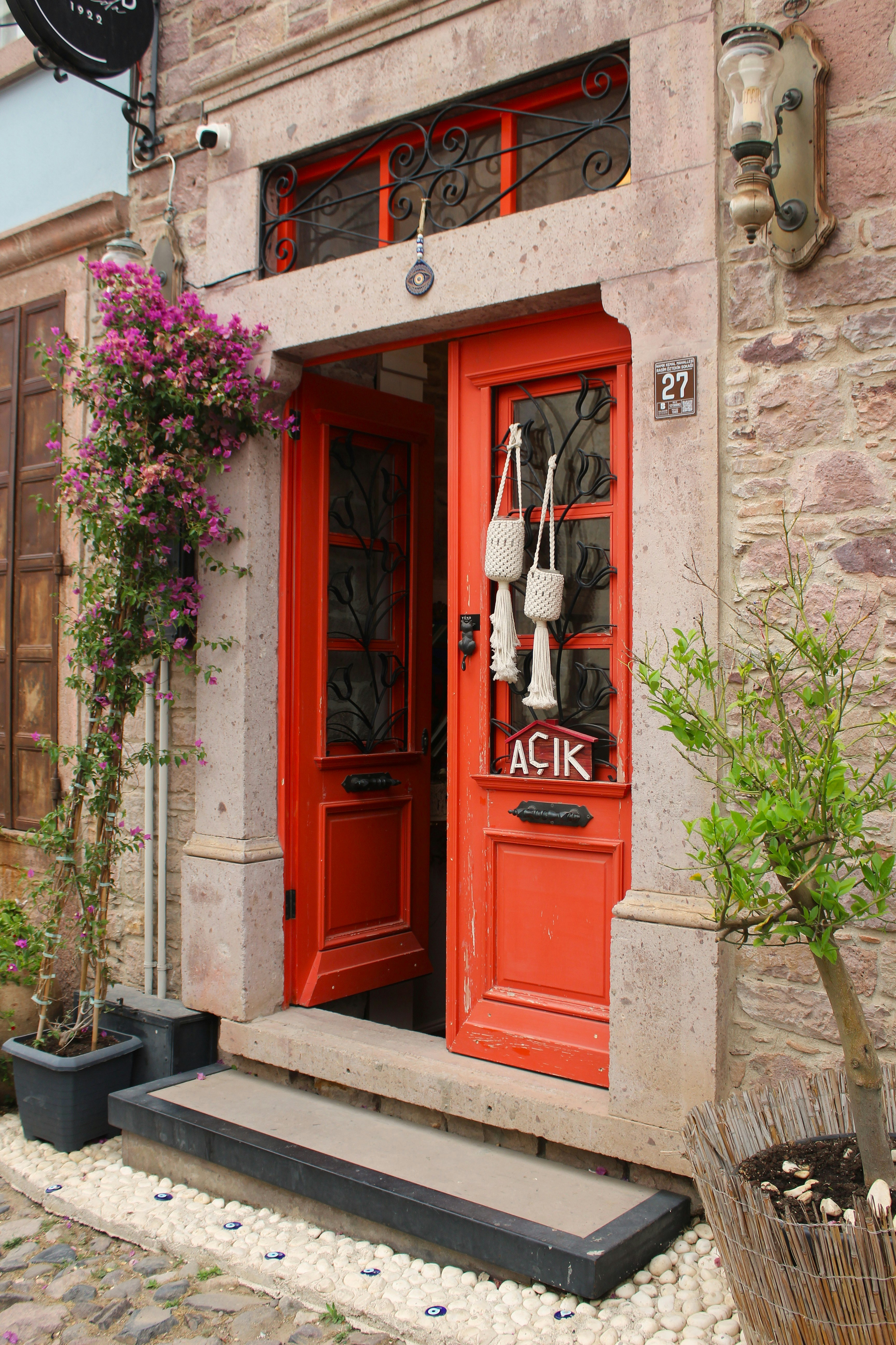 Red doors with flowers and a small tree.