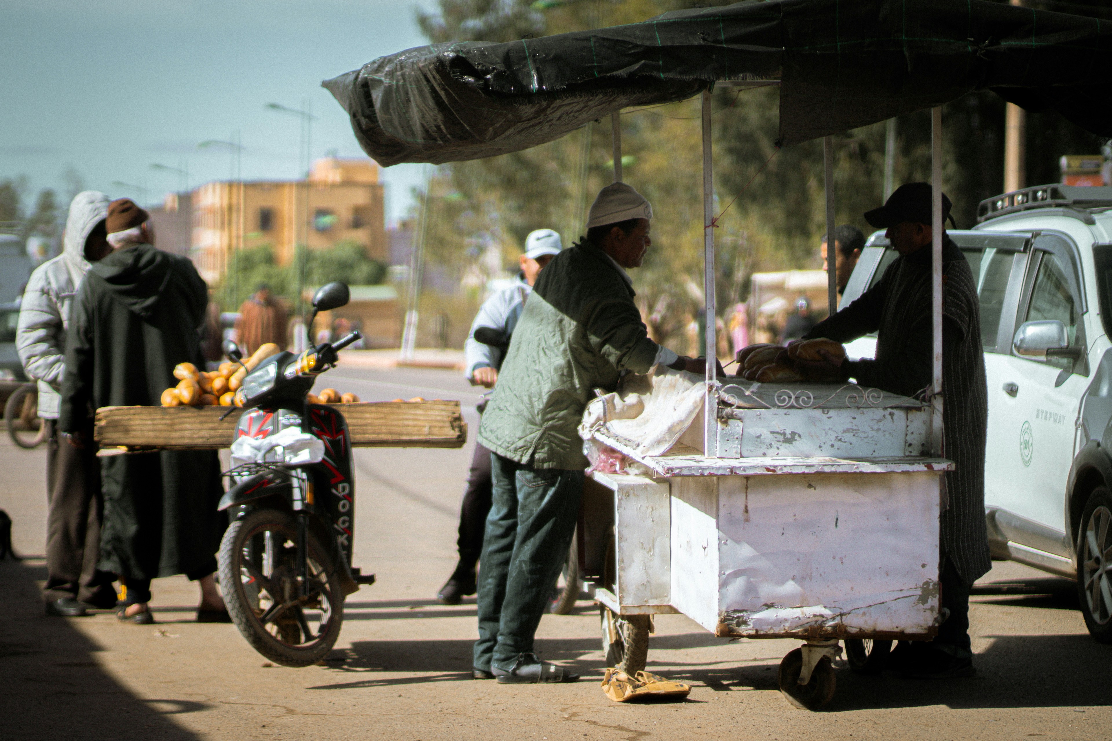 Street vendor serving customers at cart