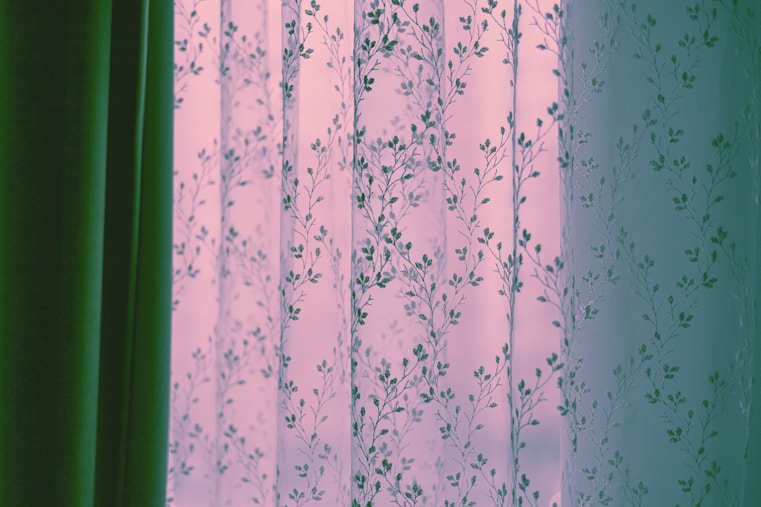 Sheer floral curtains with green drapes