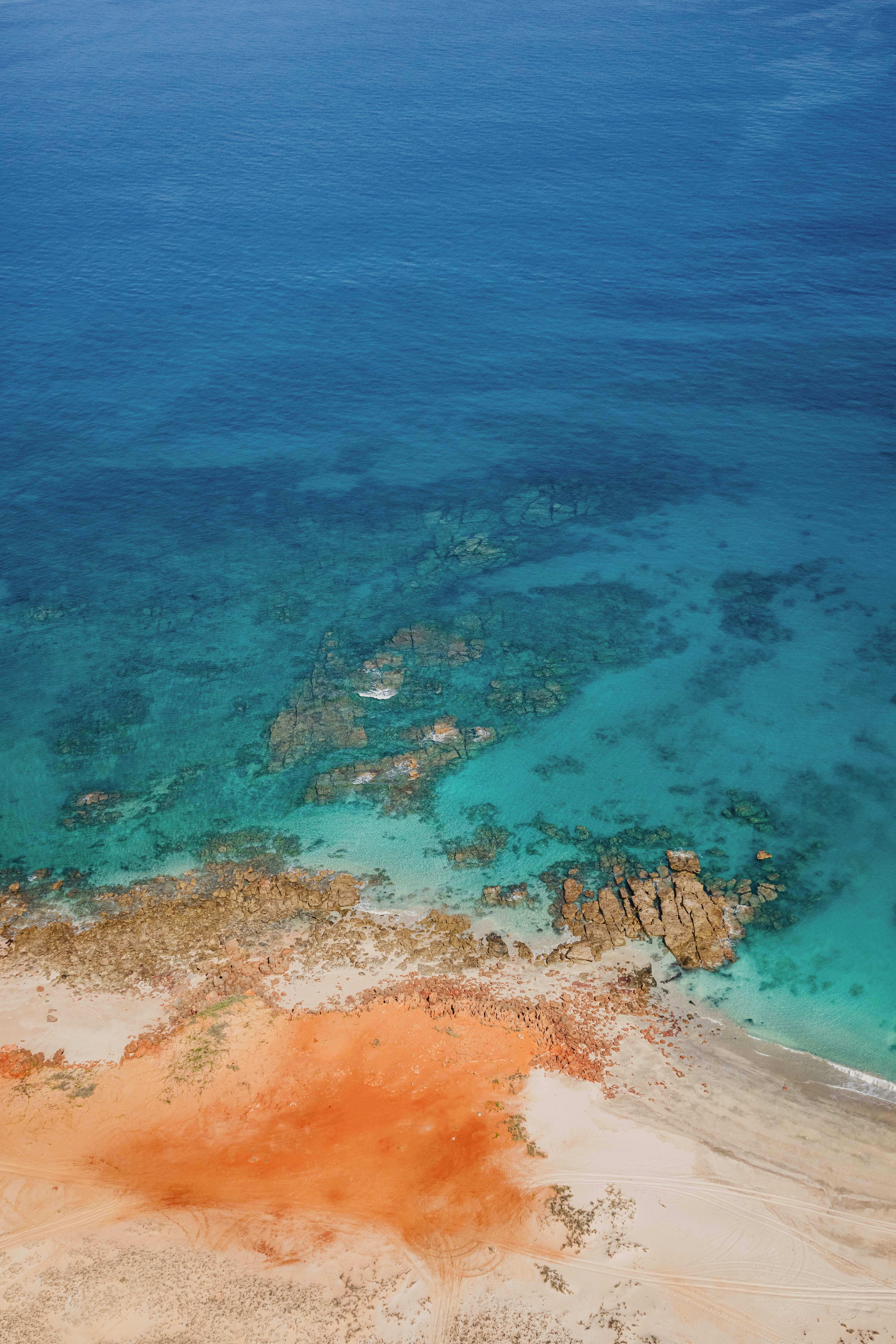 Aerial view of a tropical beach with clear turquoise water.