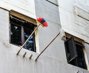 Broom and mop cleaning exterior building windows
