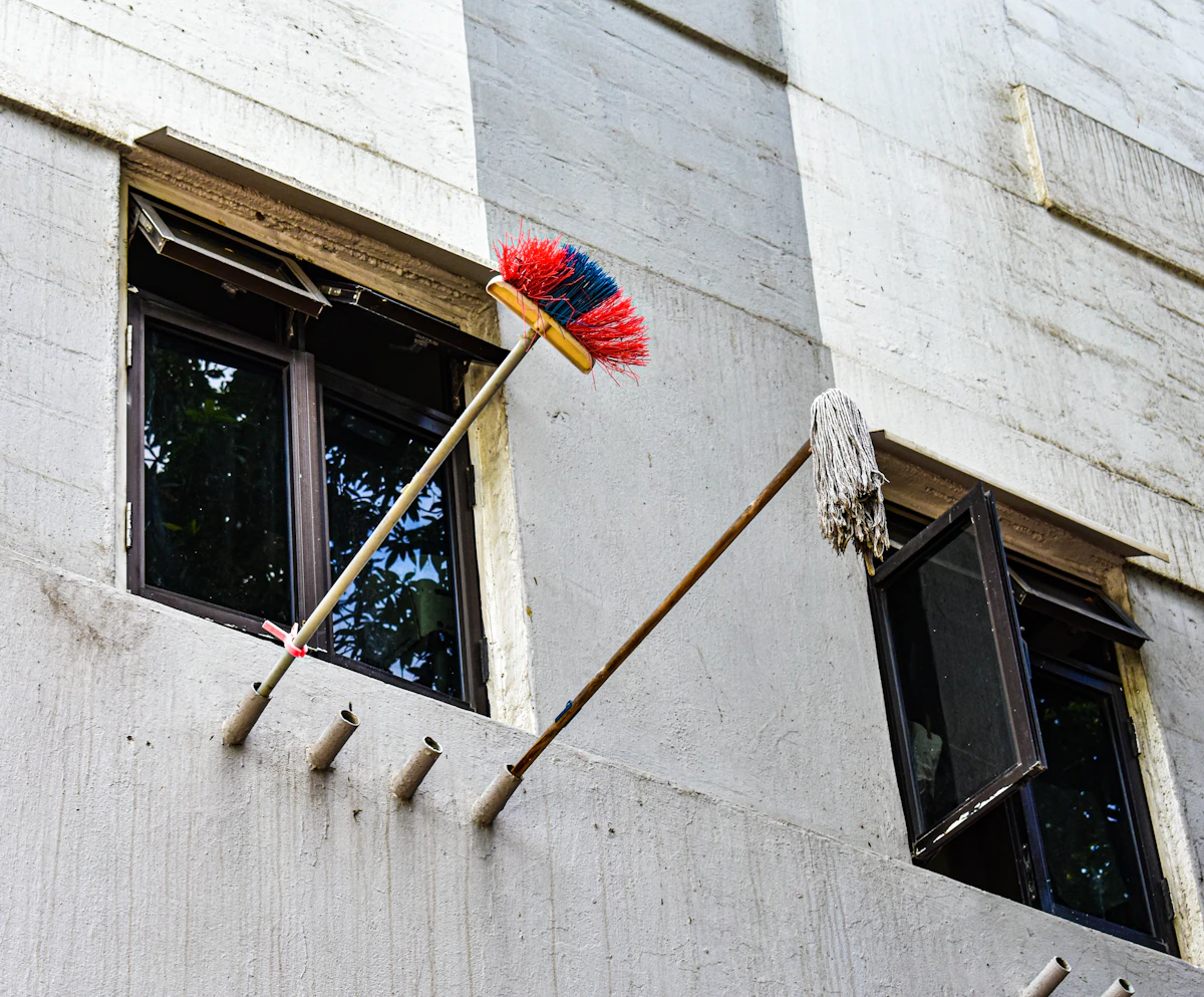 Reinigungsutensilien vor einem frisch geputzten Fenster