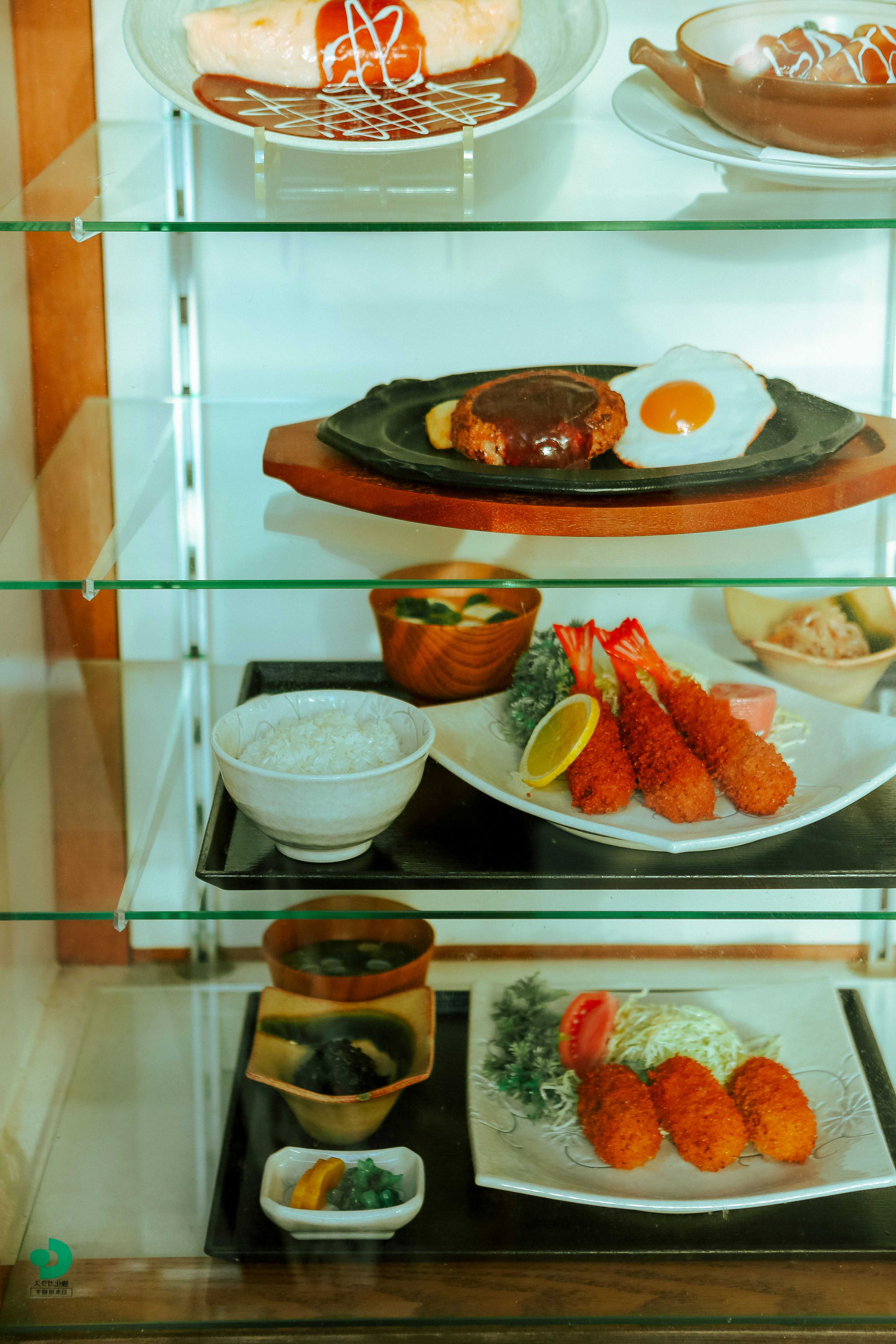 Display of japanese food items in a glass case.