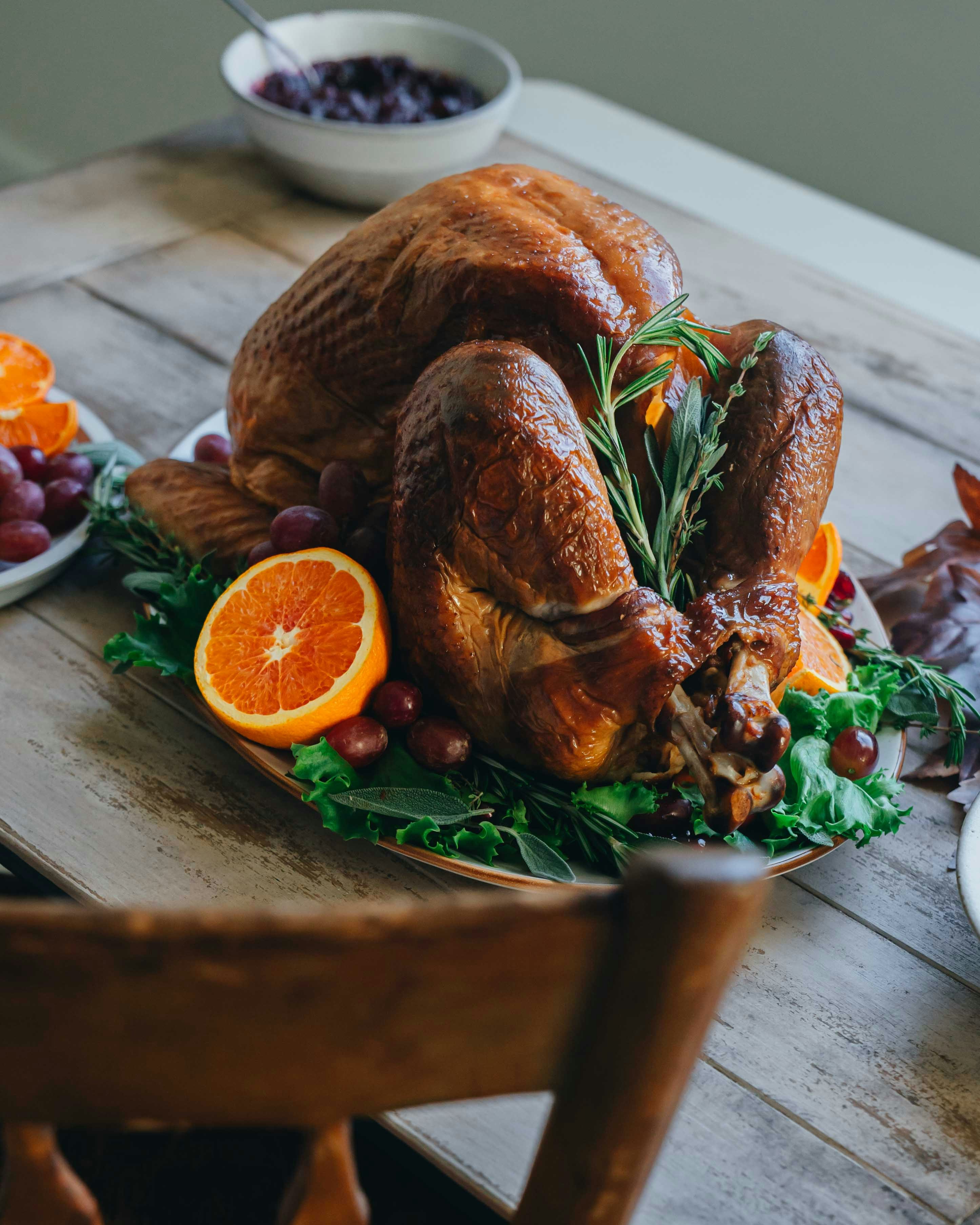 オレンジとローズマリーで飾られた黄金色のローストターキー。