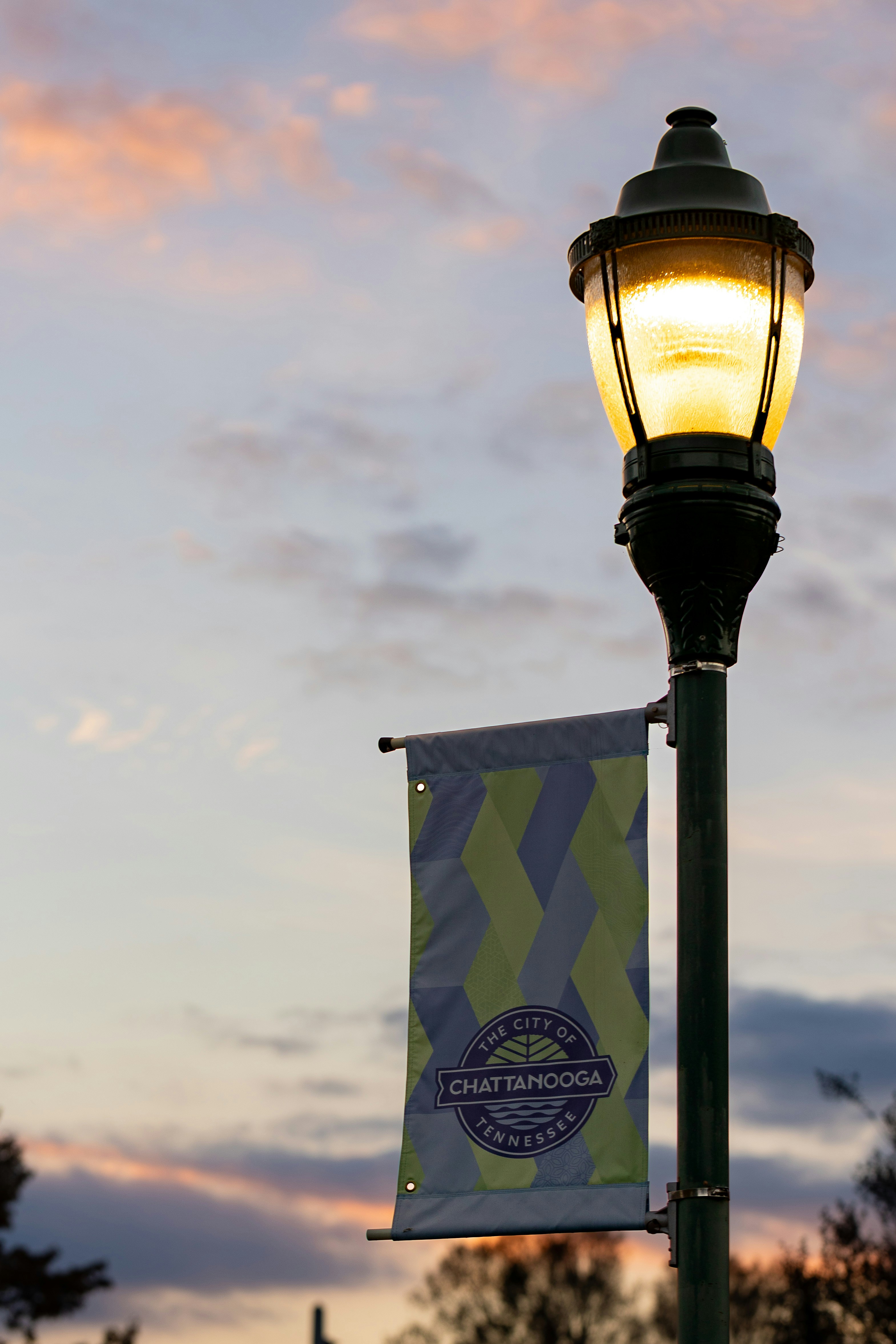 Street lamp with city banner at sunset