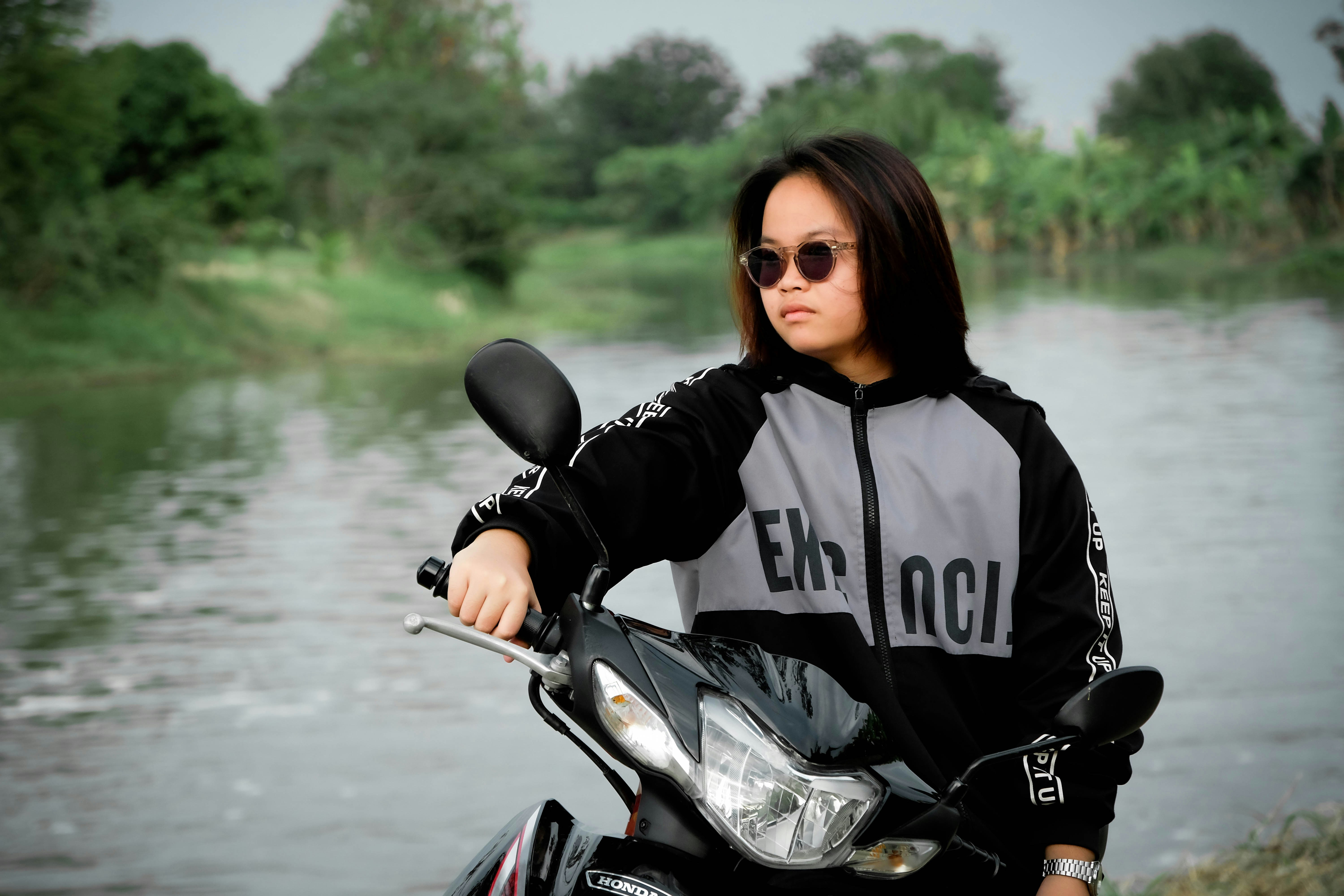 Una joven con gafas de sol está sentada en una moto.