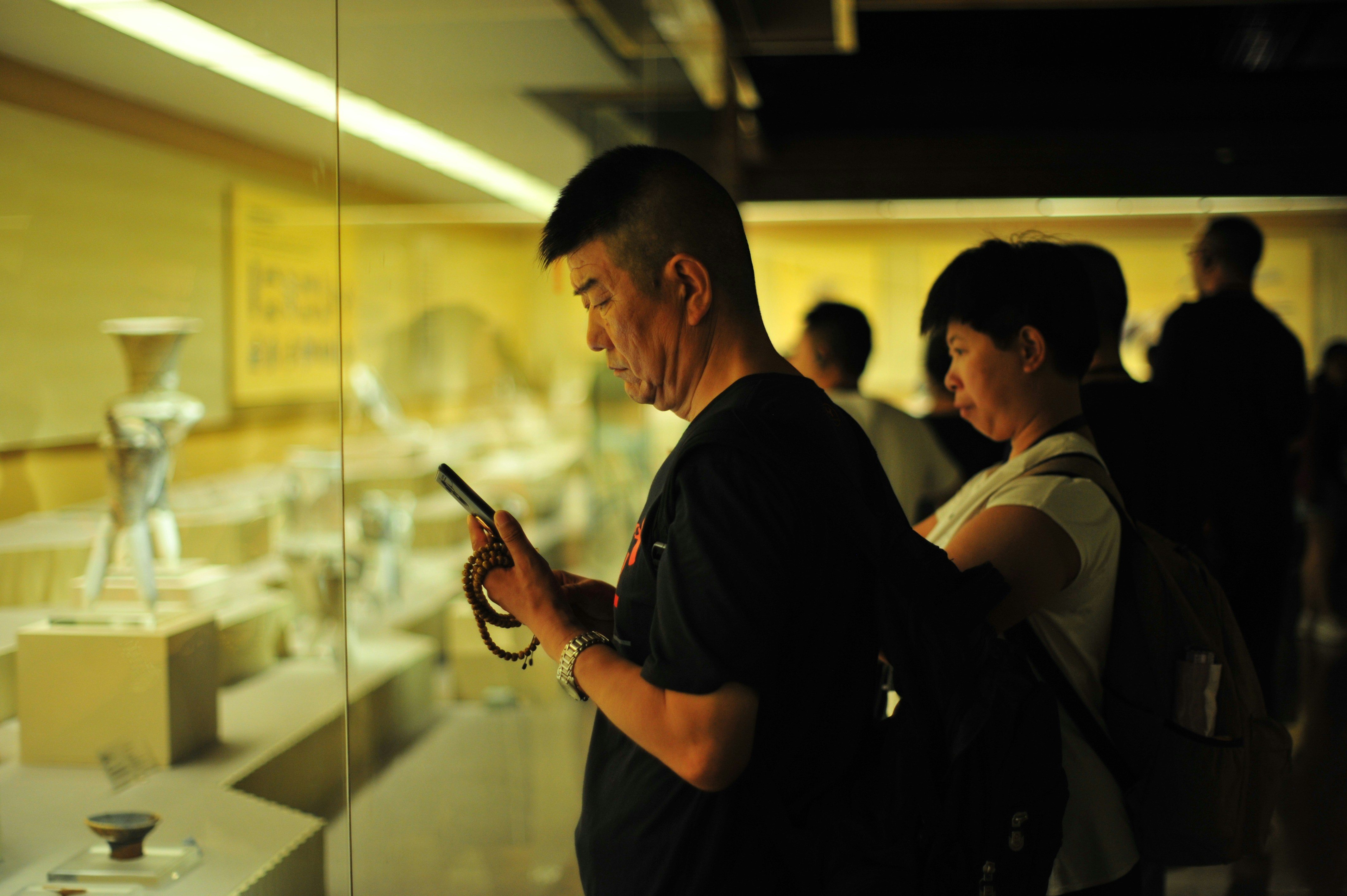 People looking at artifacts in a museum exhibit.