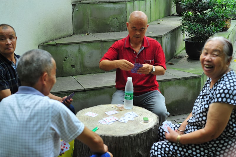 Elderly people playing cards together outdoors