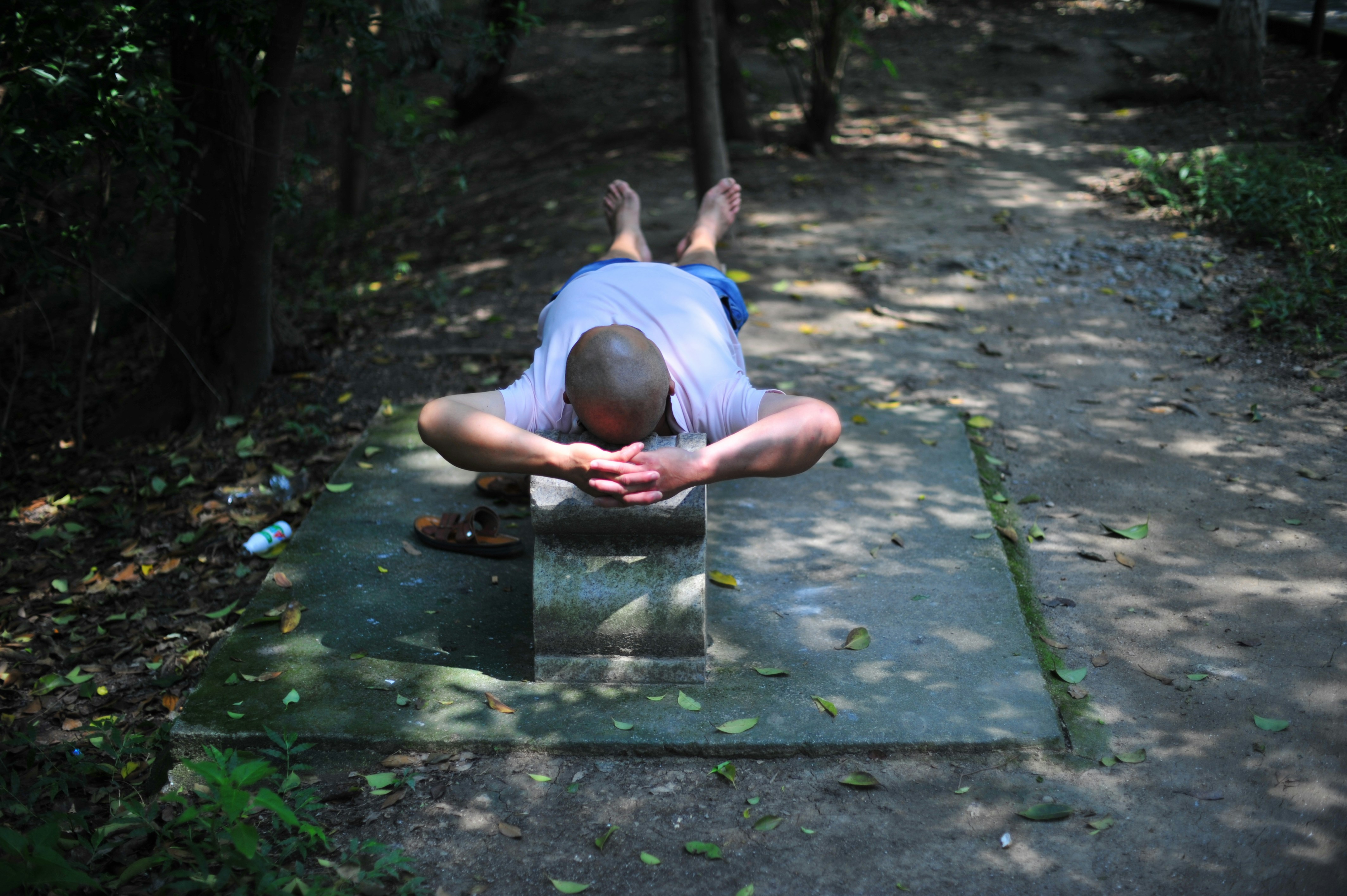 Hombre descansando sobre una estructura de hormigón al aire libre