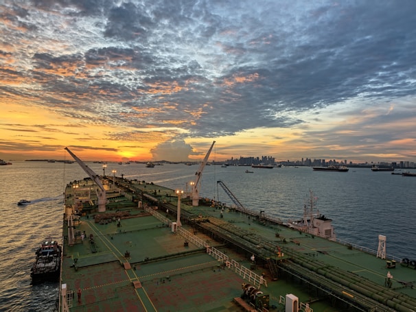 Large ship sailing into harbor at sunset