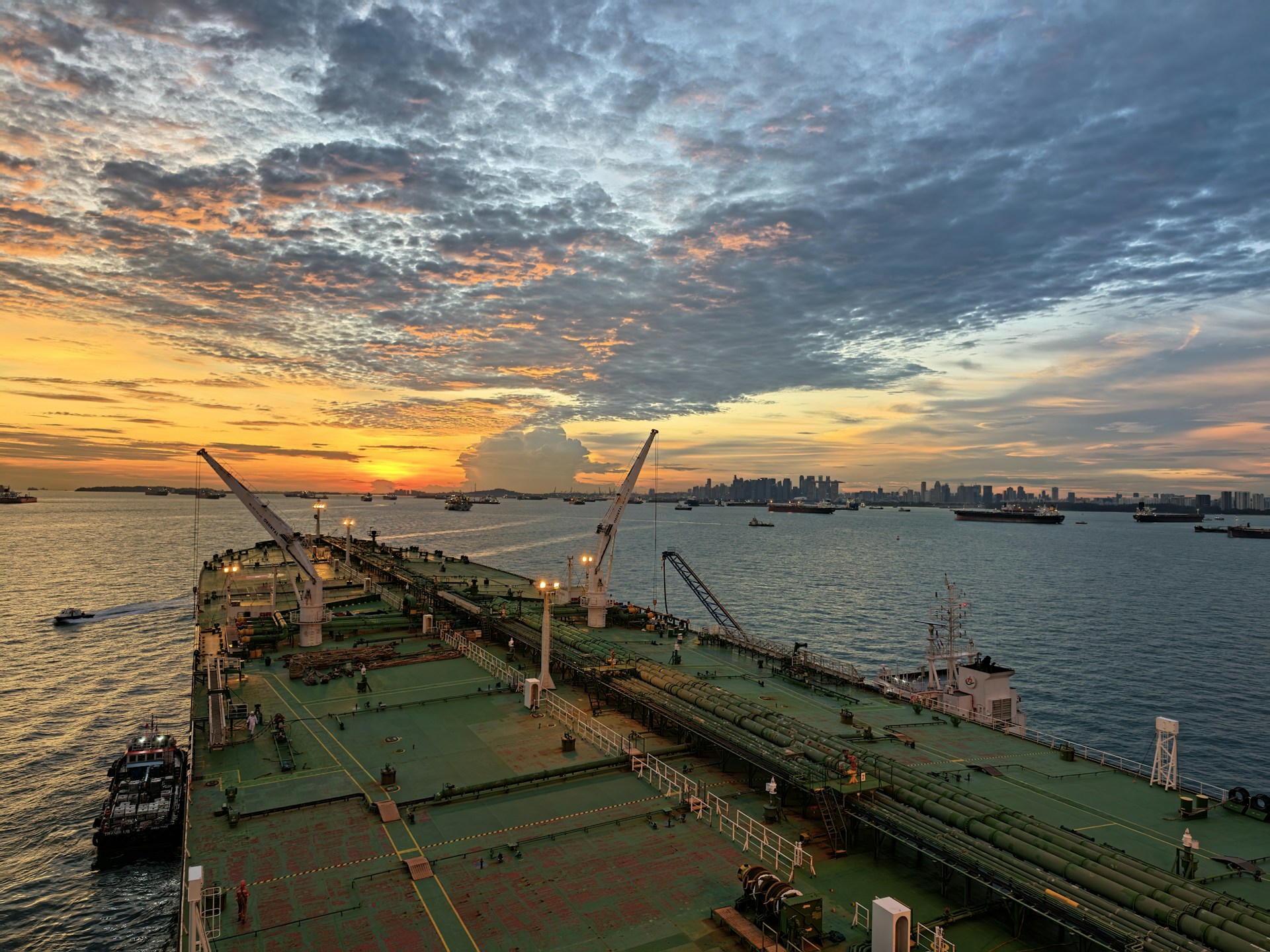 Large ship sailing into harbor at sunset